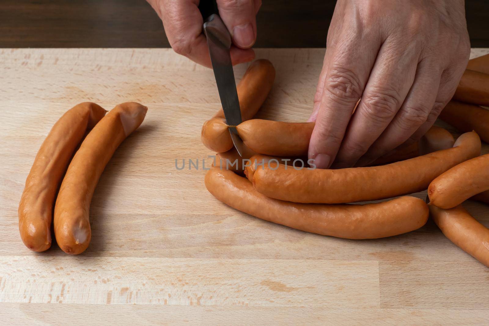 Thin pork sausages on the wooden cutting board by xtrekx