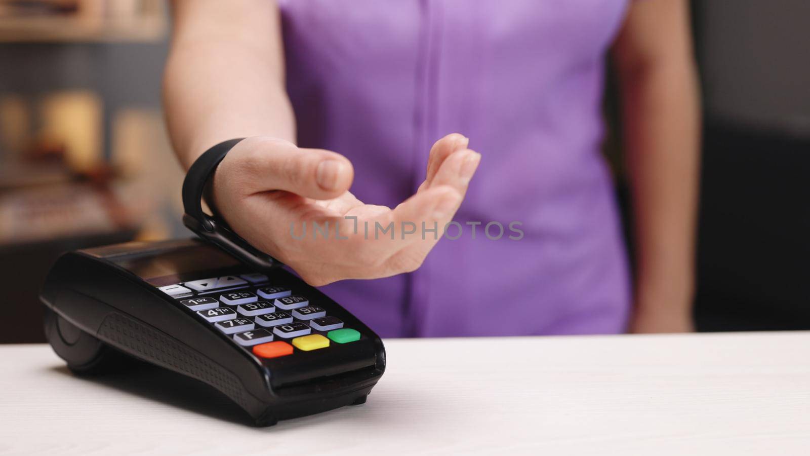 Contactless payment with your smart watch. Wireless payment concept. Close-up, woman using smartwatch cashless wallet NFC technology to pay order on bank terminal. Mobile payment by uflypro