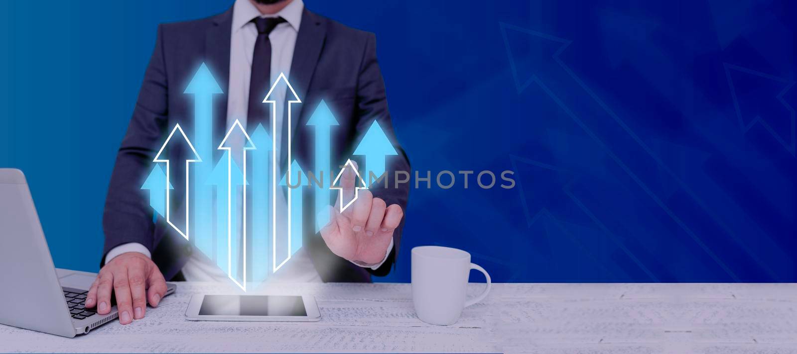 Businessman With A Laptop And Tablet With Hand Pointing On Multiple Arrows Going Up In Abstract Design. Man In Suit Working On Chart Presentations And Important Information. by nialowwa