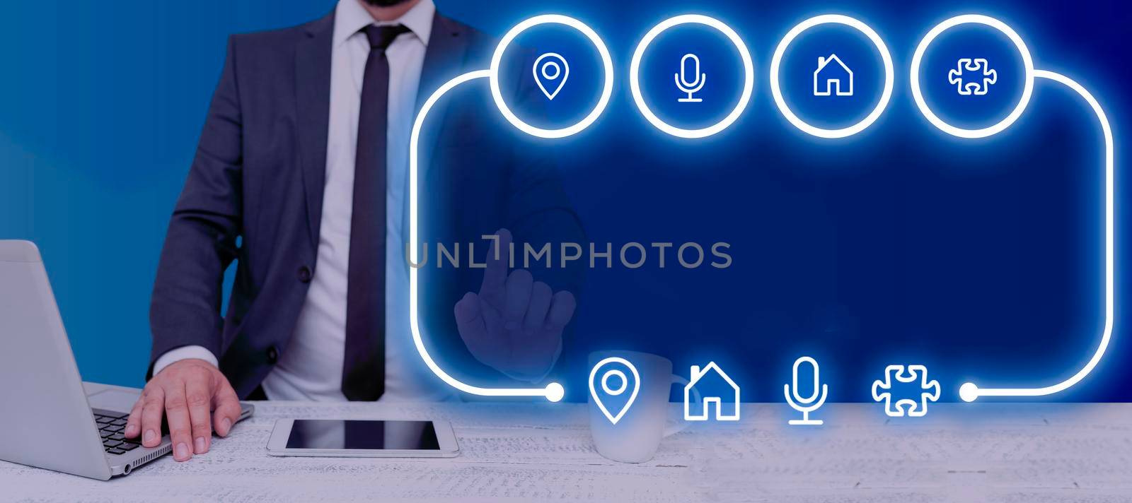 Businessman With A Laptop And A Tablet With Hand Pointing On Glowing Digital Signs In A Futuristic Design. Man Giving A Presentation With Important Information And Concepts. by nialowwa