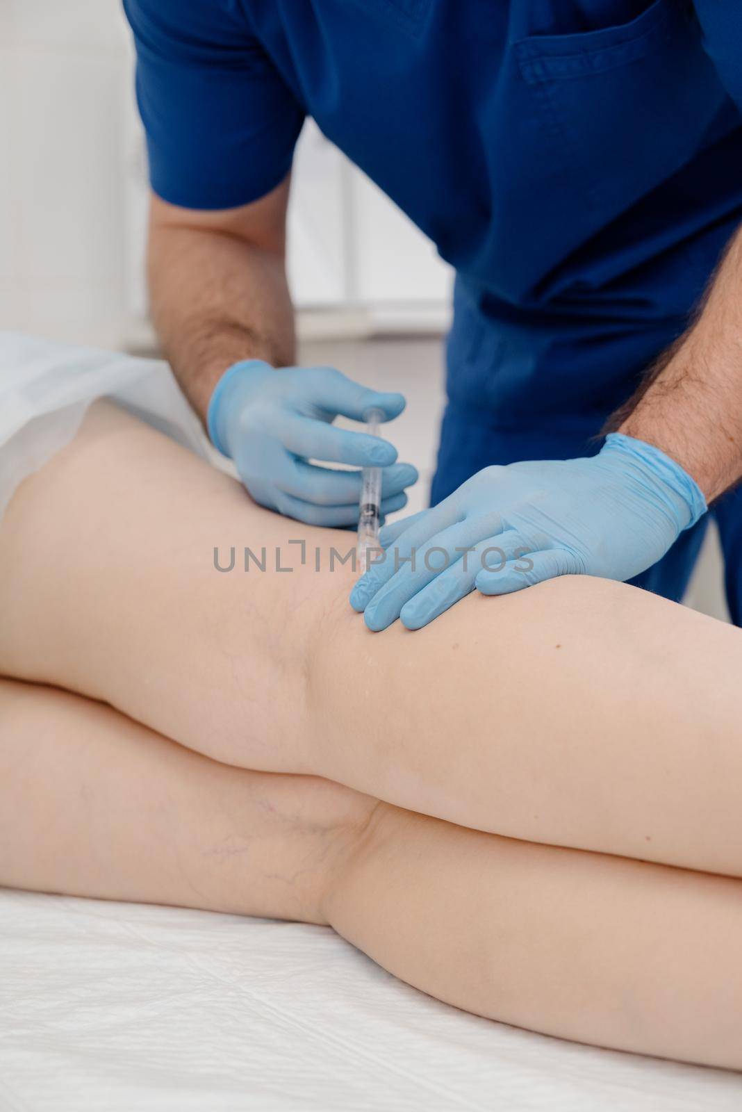 Removal of varicose veins on the legs.The doctor performs a medical sclerotherapy procedure used to eliminate varicose veins and vascular asterisks.