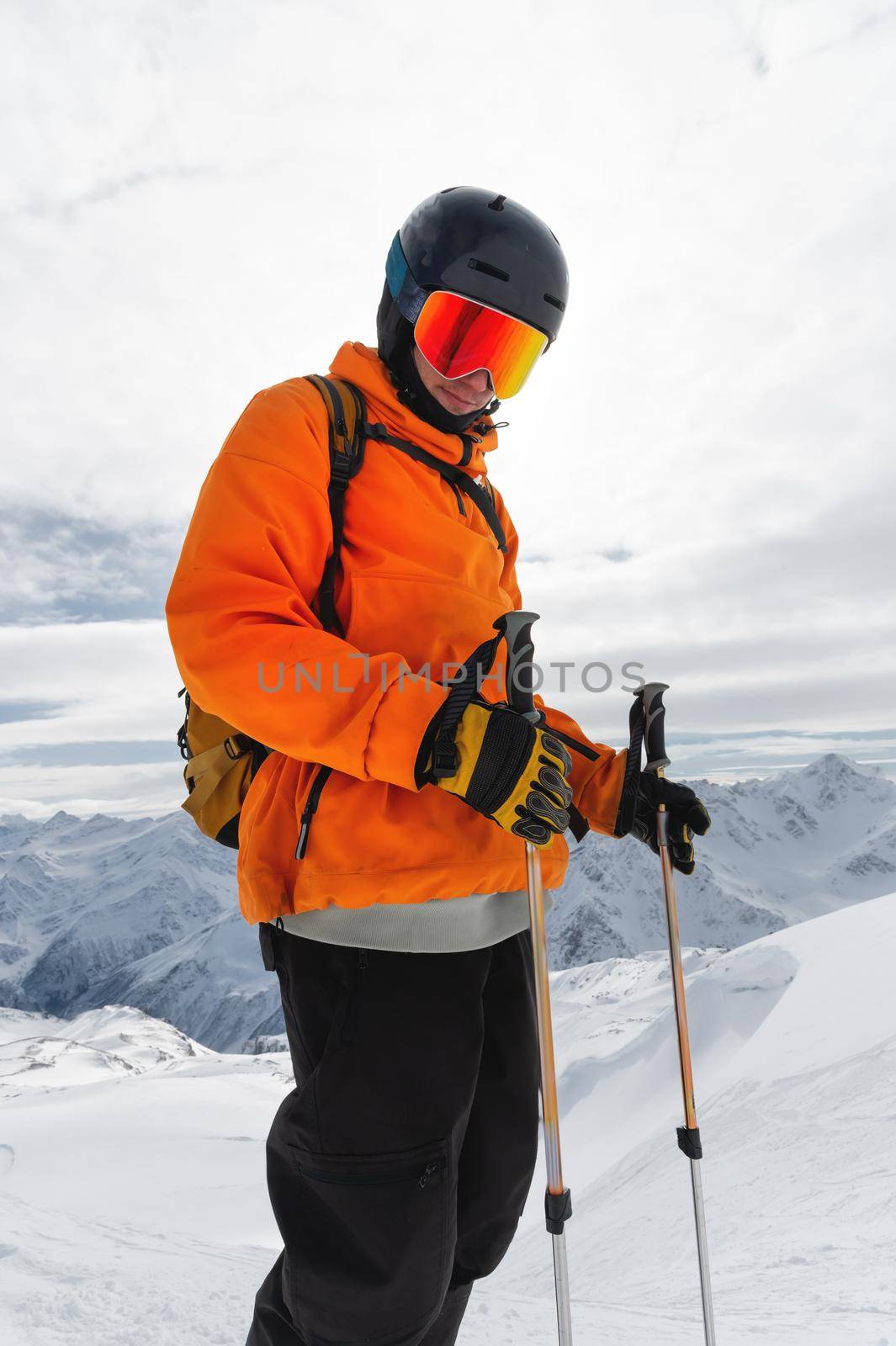 Portrait of a male skier at the top against the backdrop of epic mountains in the clouds. by yanik88