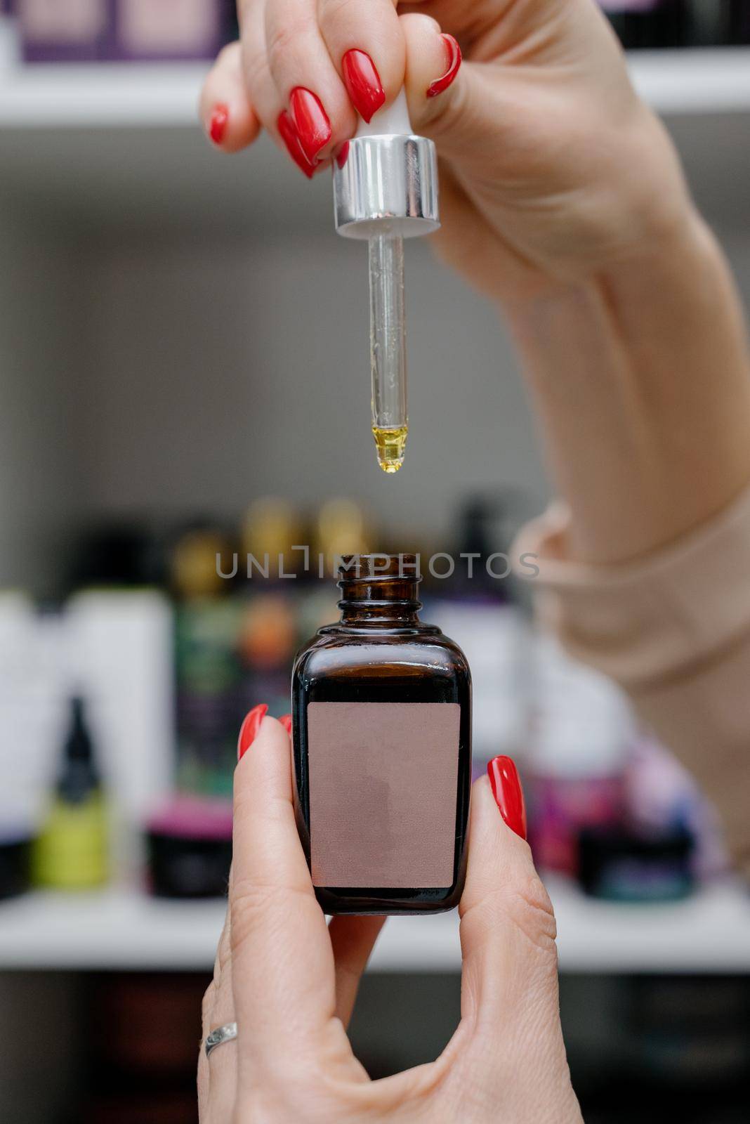 Oil hair treatment for woman. Concept hairdresser spa salon.A drop falls from a pipette into a medical bottle close-up