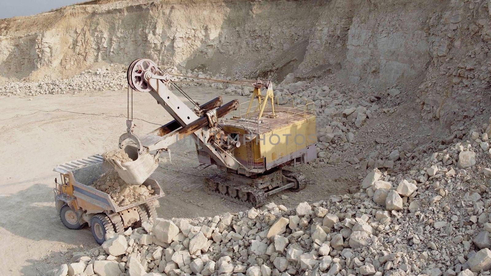 Large electric bucket excavator loads coal into a large dump truck. Mining industry. Heavy industry