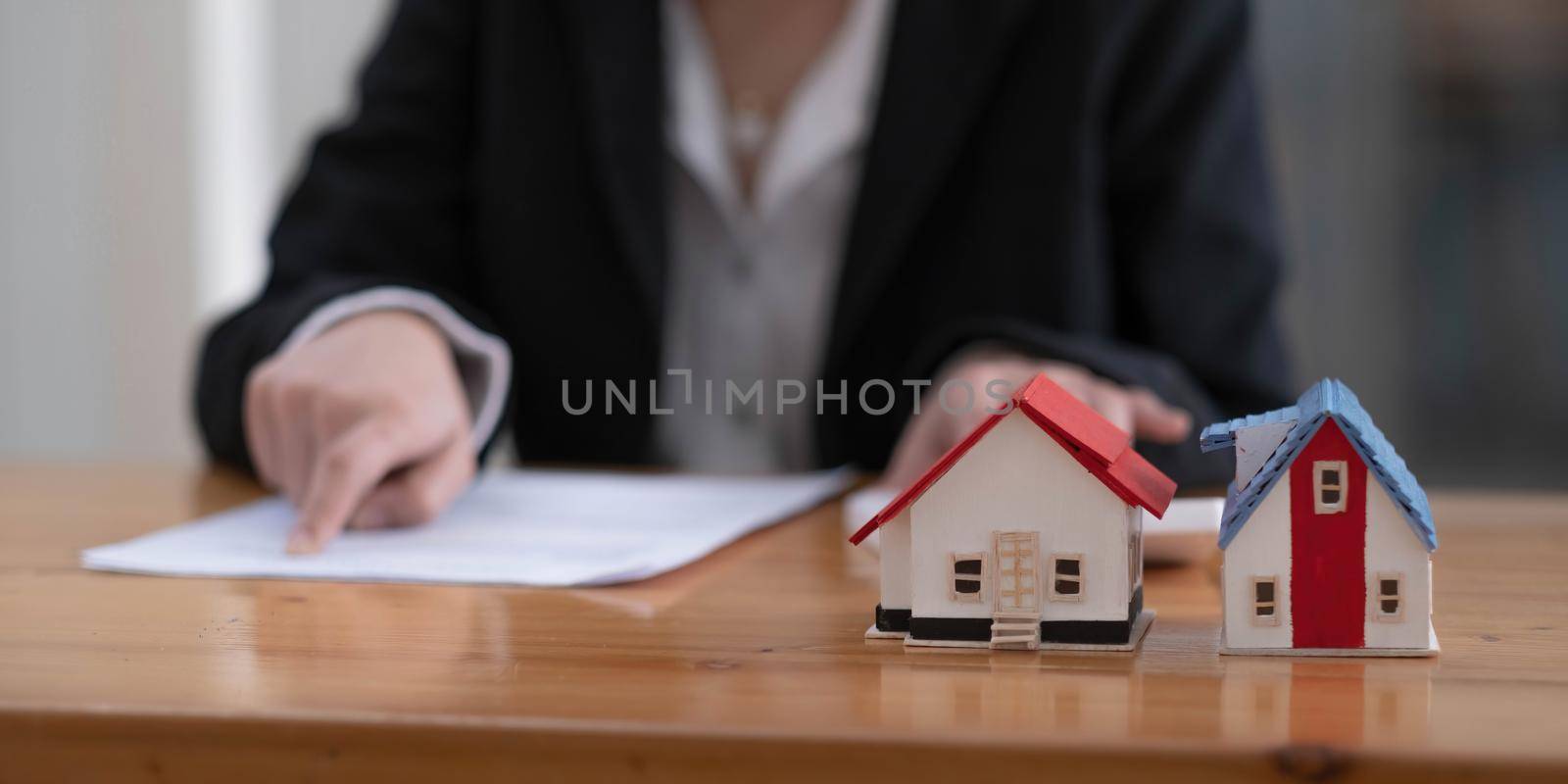 Businesswoman present contact of house insurance contract to purchase a home with a real estate agent..
