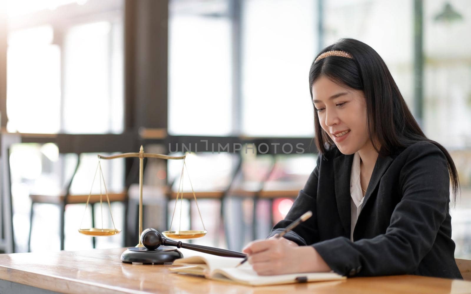 Business and lawyers discussing contract papers with brass scale on desk in office. Law, legal services, advice, justice and law concept picture with film grain effect.