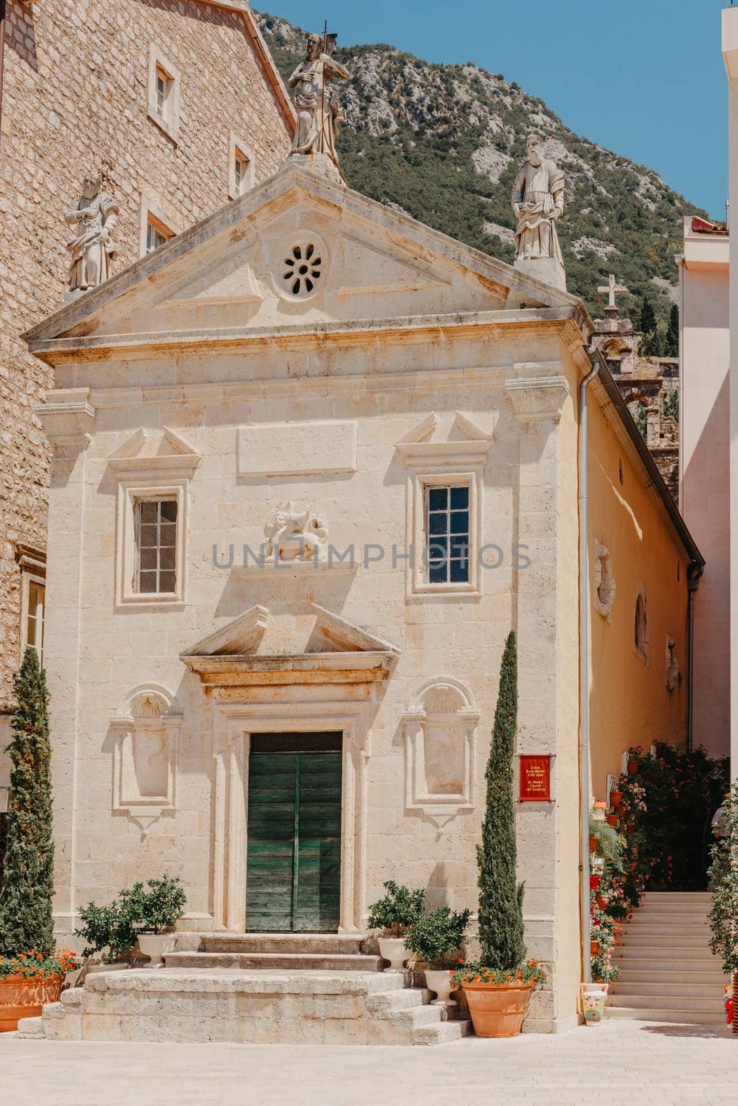 Historic city of Perast at Bay of Kotor in summer, Montenegro. Scenic panorama view of the historic town of Perast at famous Bay of Kotor with blooming flowers on a beautiful sunny day with blue sky and clouds in summer, Montenegro, southern Europe by Andrii_Ko