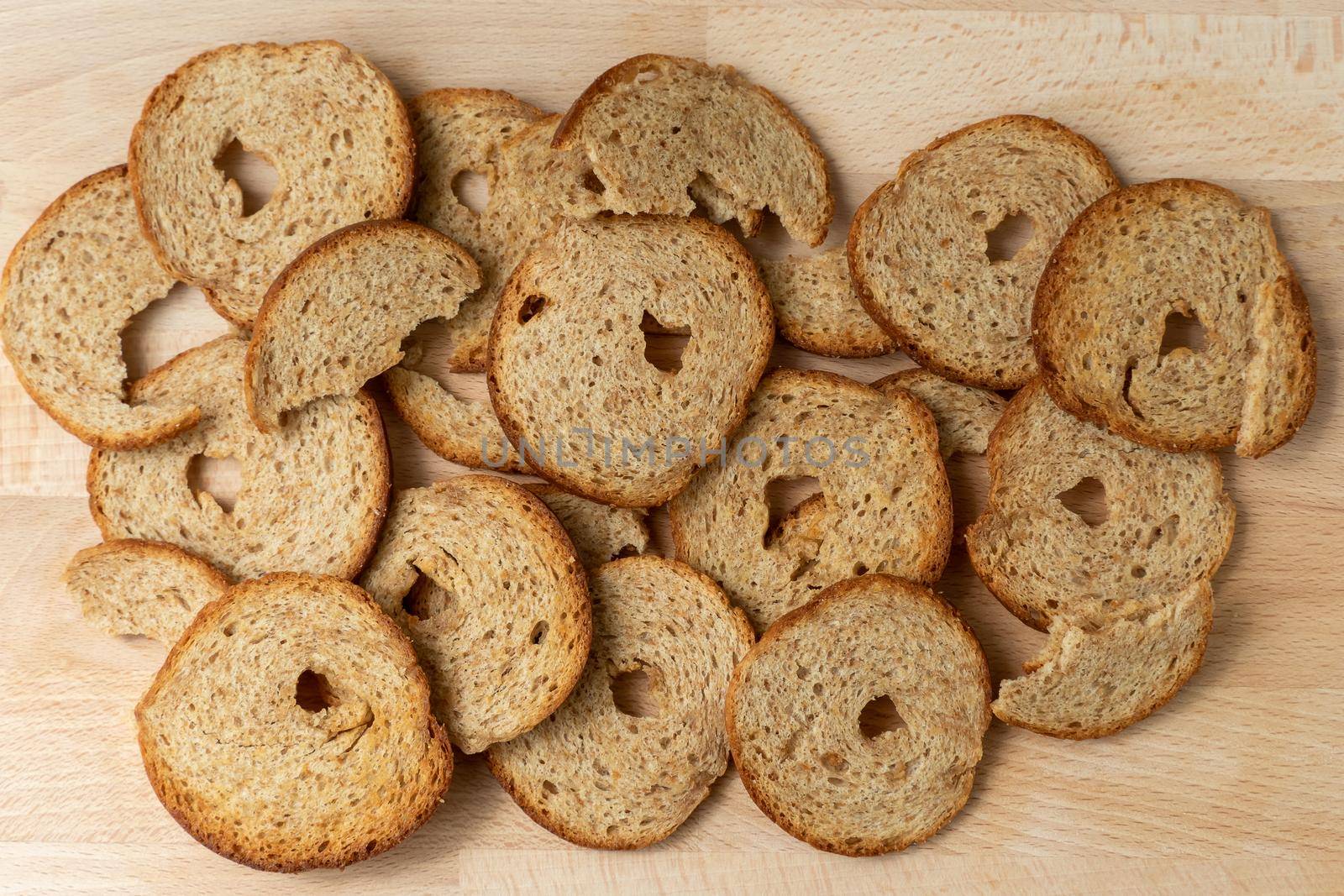 Mini rolls of baked bread on wooden background. Bread chips.