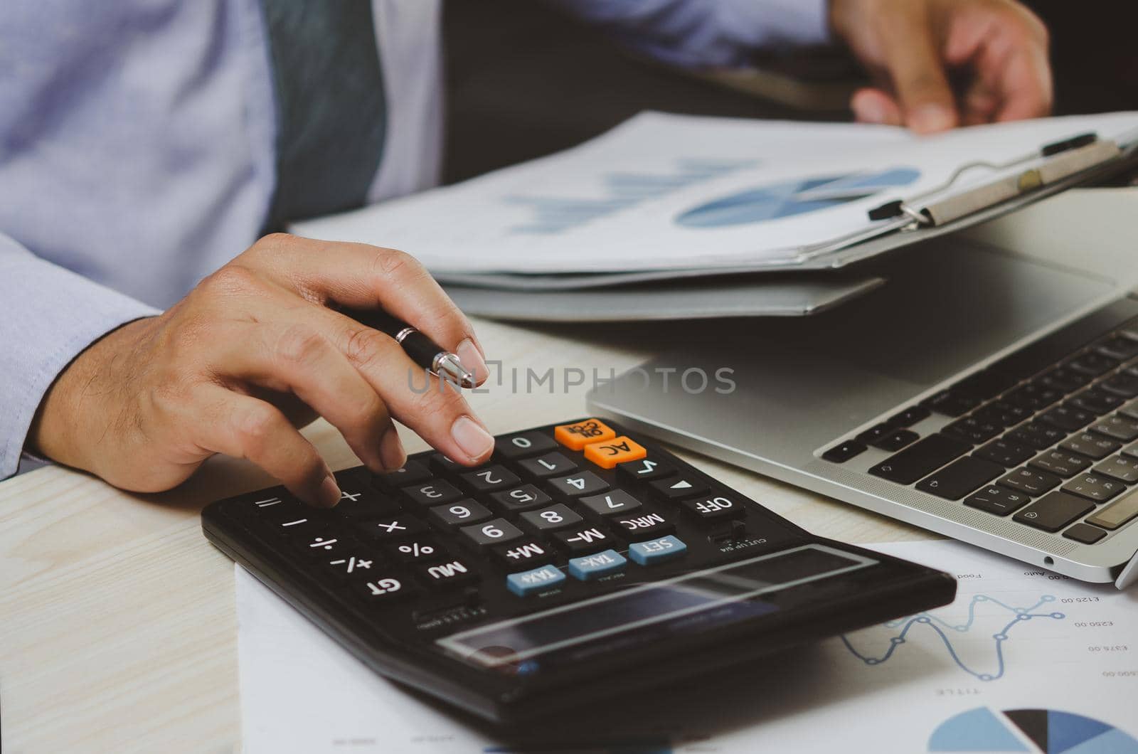 businessman holding calculators and business documents charts statistical data investment analysis and tax accounting. by aoo3771