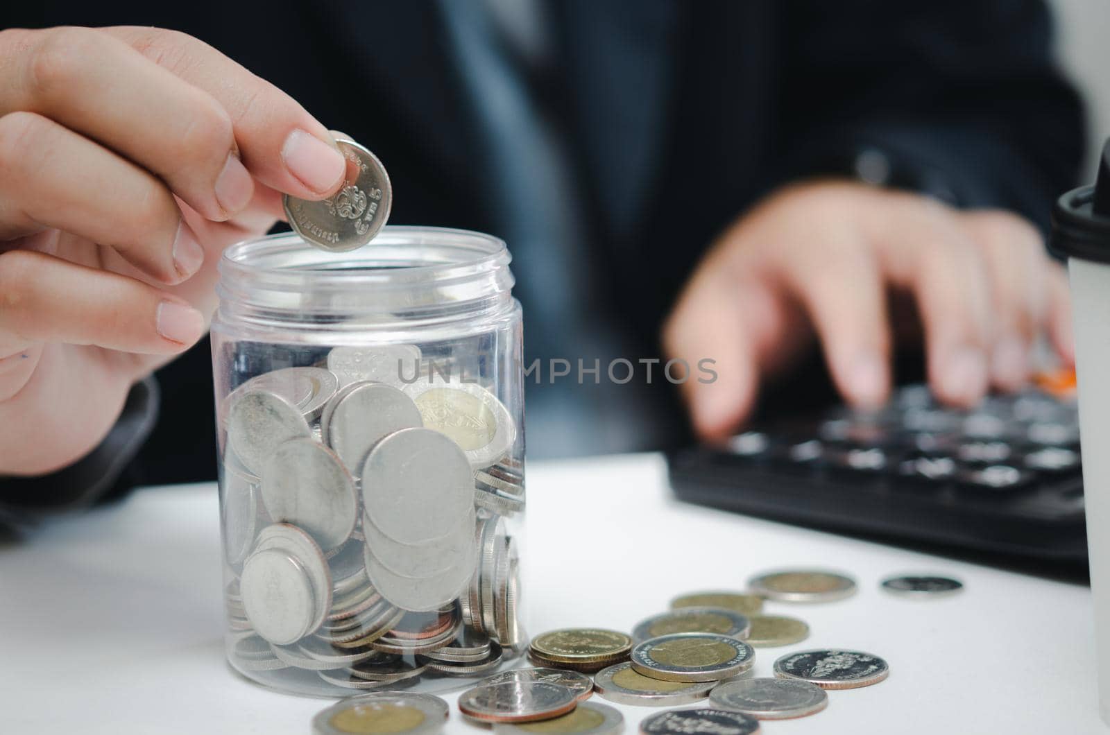 Retirement planning or investment accounting business concept finance insurance tax. Businessman person holding saving coin money in jar and calculator at desk.