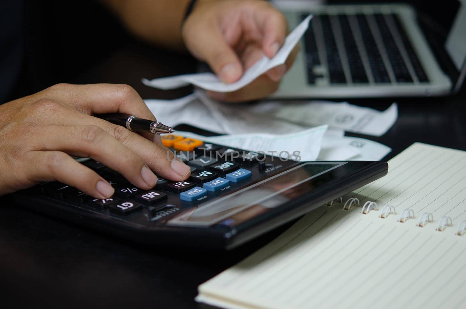 Man hand holding pen and calculator bills or tax receipt. business finance concept.