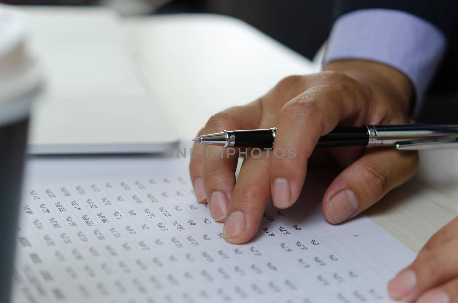 Businessman hands use pen to document business percentage figures. Finance and accounting analysis of economic and investment business concept. by aoo3771