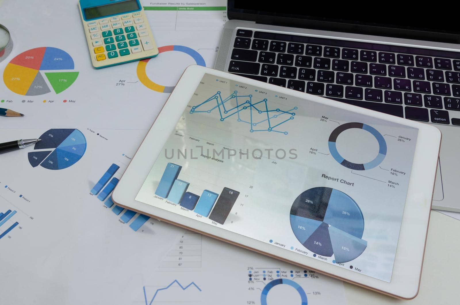 Document paperwork graph and chart at tablet with computer laptop and pen. Business finance analysis report marketing and information investment accounting at office digital technology concept.
