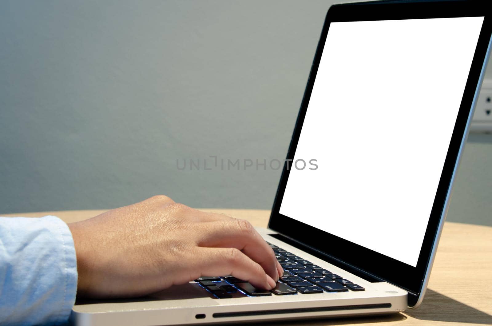 man hand using keyboard computer laptop mock up blank screen on desk.