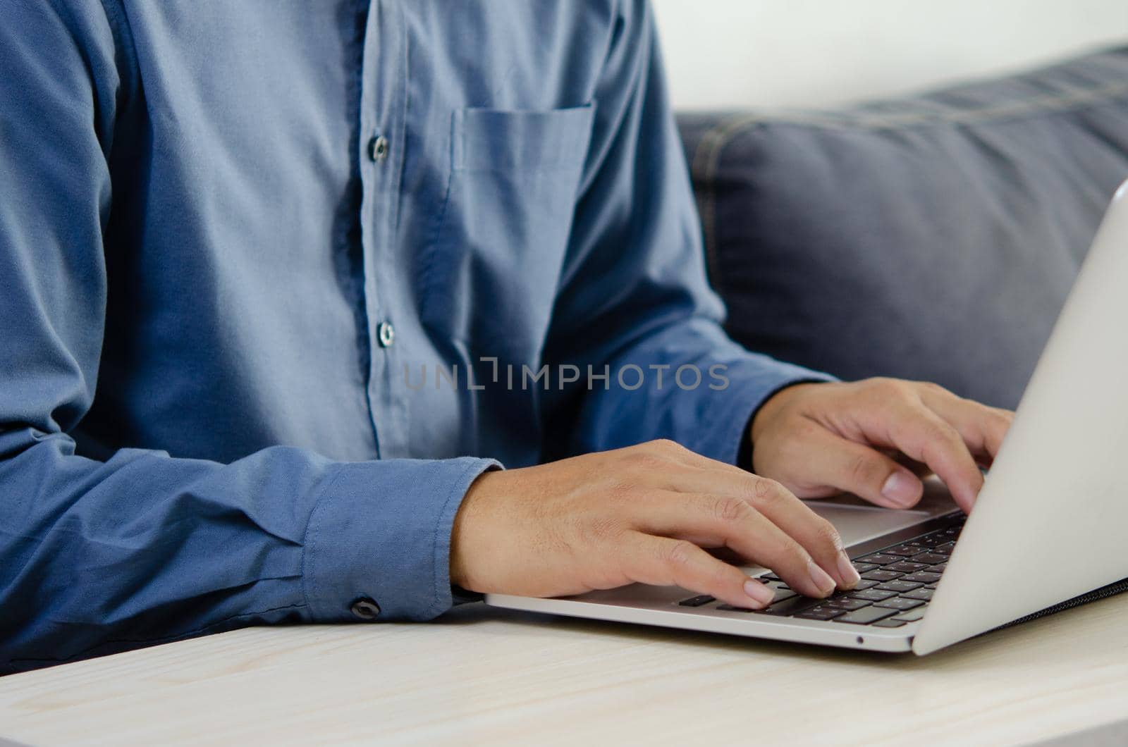 Businessman hand typing keyboard on laptop computer. Close up businessman communicating internet and social media at his desk.