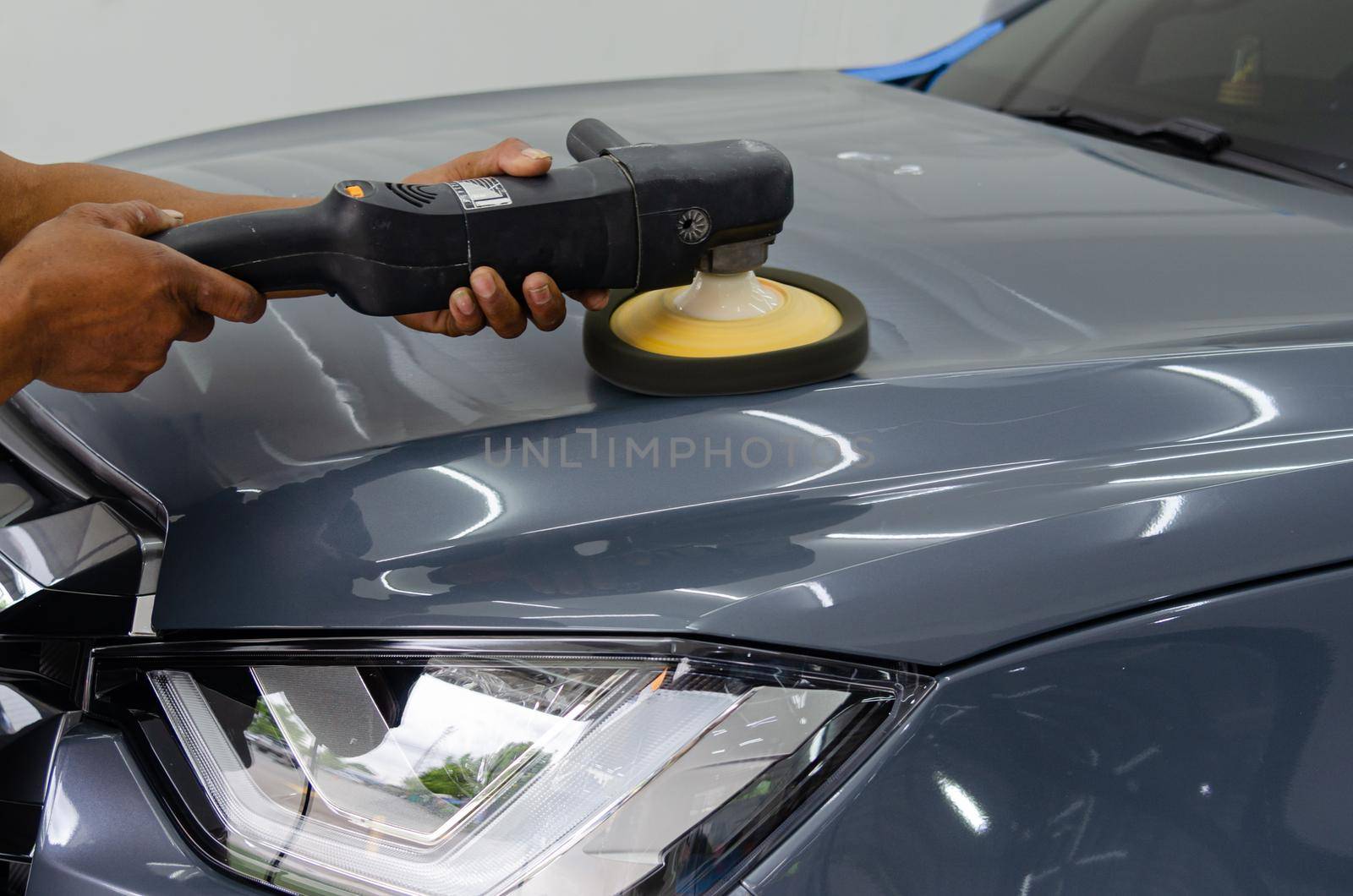 Man holding tool polish mechanic auto repair detailing hood car scratch maintenance in garage carwash job. by aoo3771