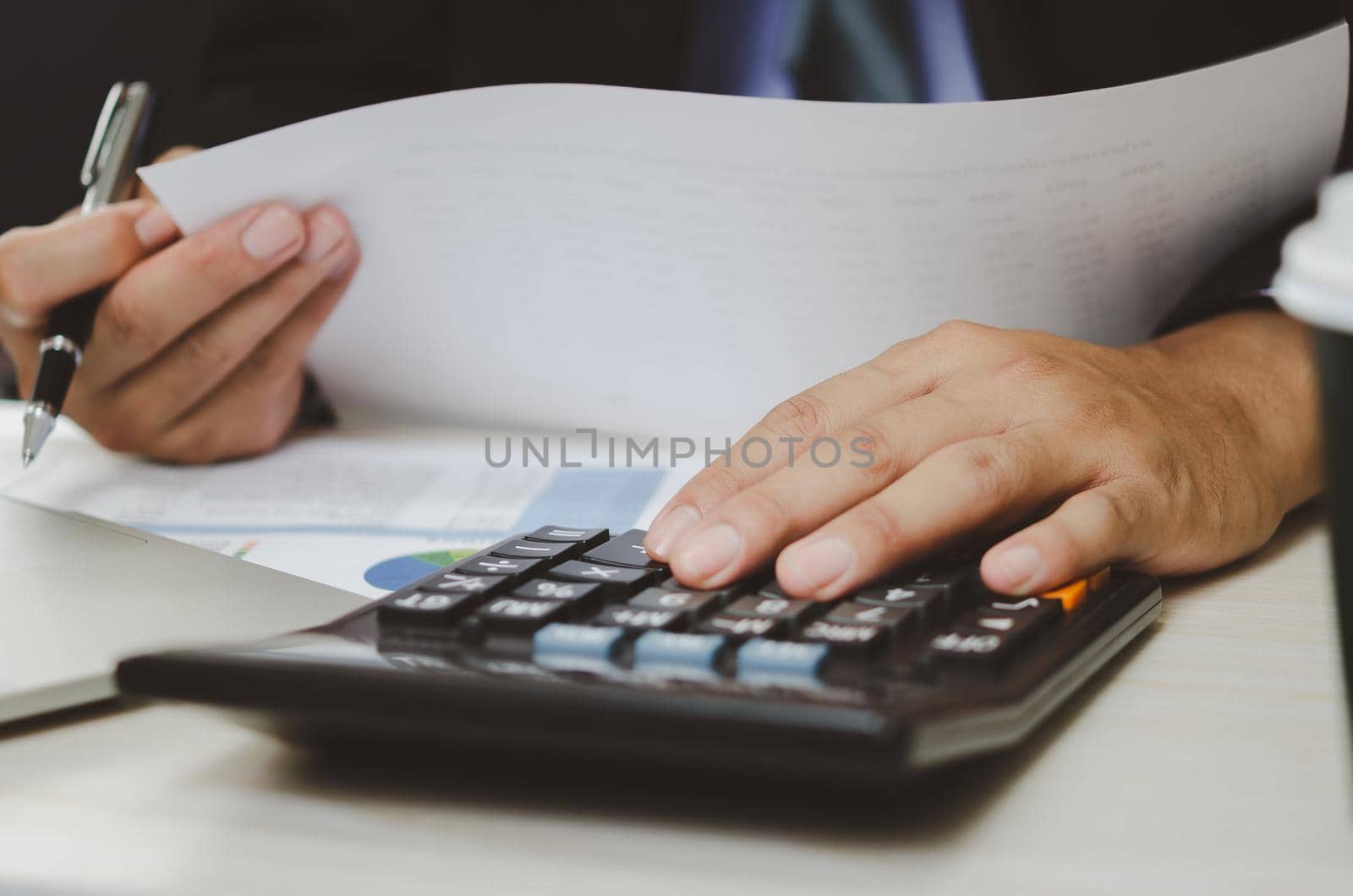 businessman holding calculators and business documents charts statistical data investment analysis and tax accounting. by aoo3771