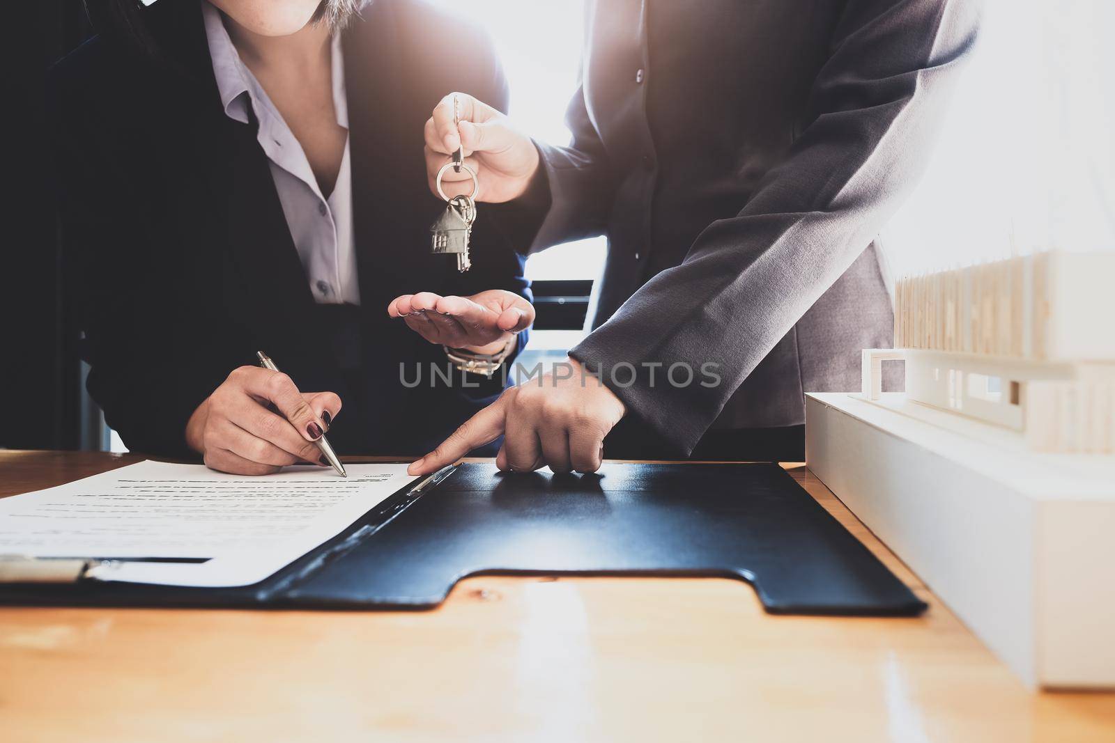 Real estate agents agree to buy a home and give keys to clients at their agency's offices. Concept agreement. by Manastrong