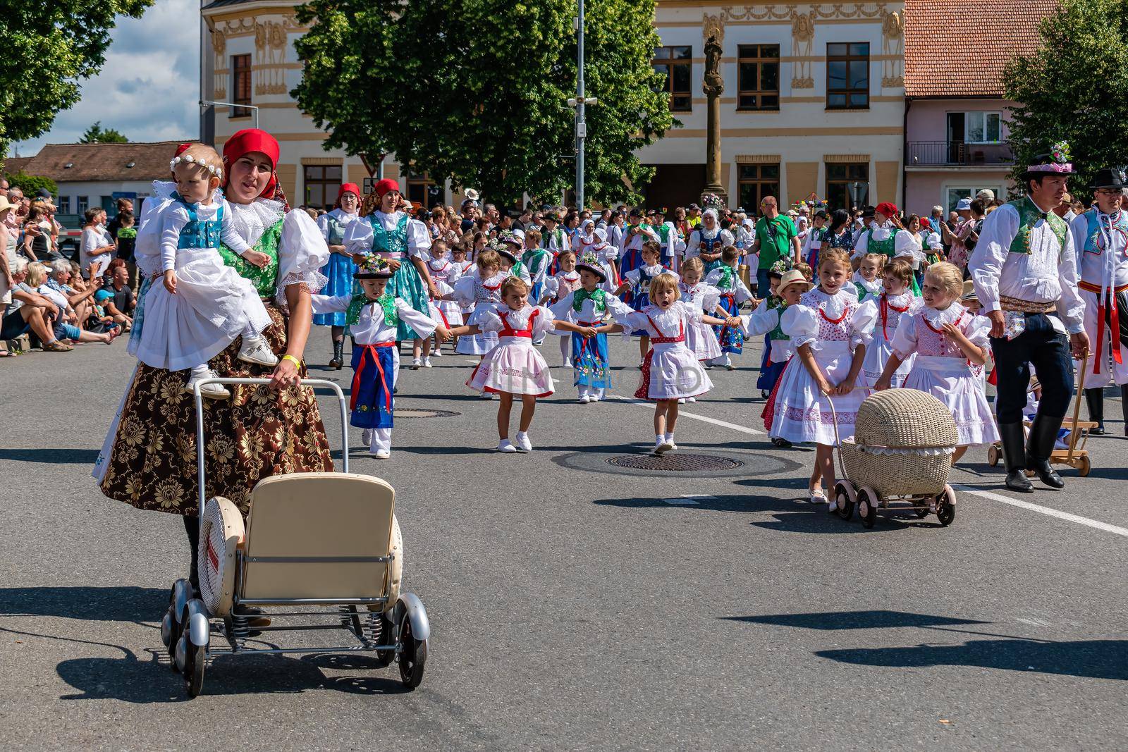 Children and women with strollers in traditional costumes by rostik924