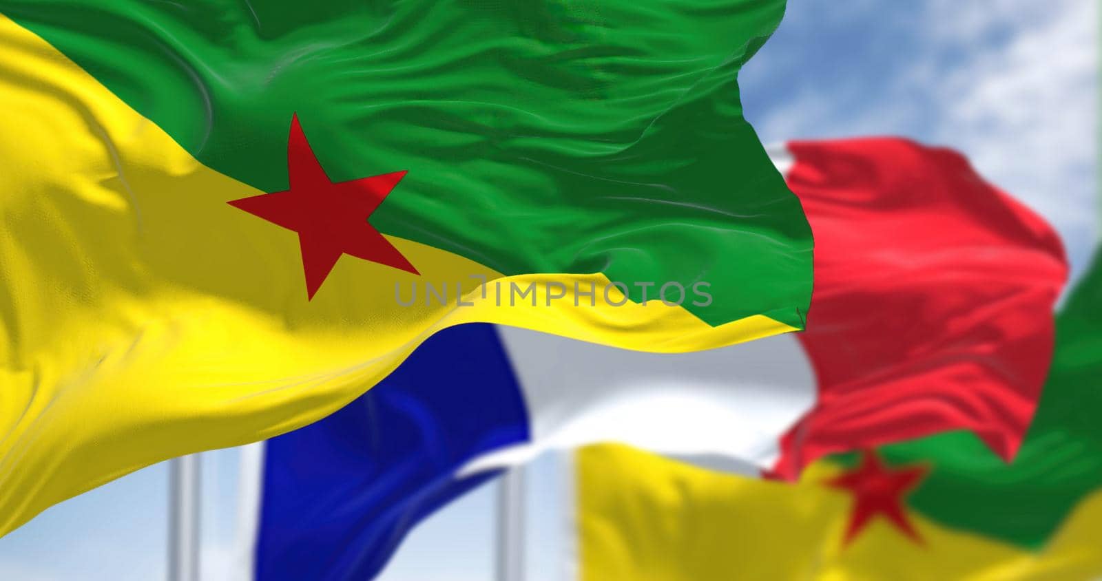 National flags of French Guiana waving with the flag of France on a clear day. French Guiana is an overseas department/region and single territorial collectivity of France