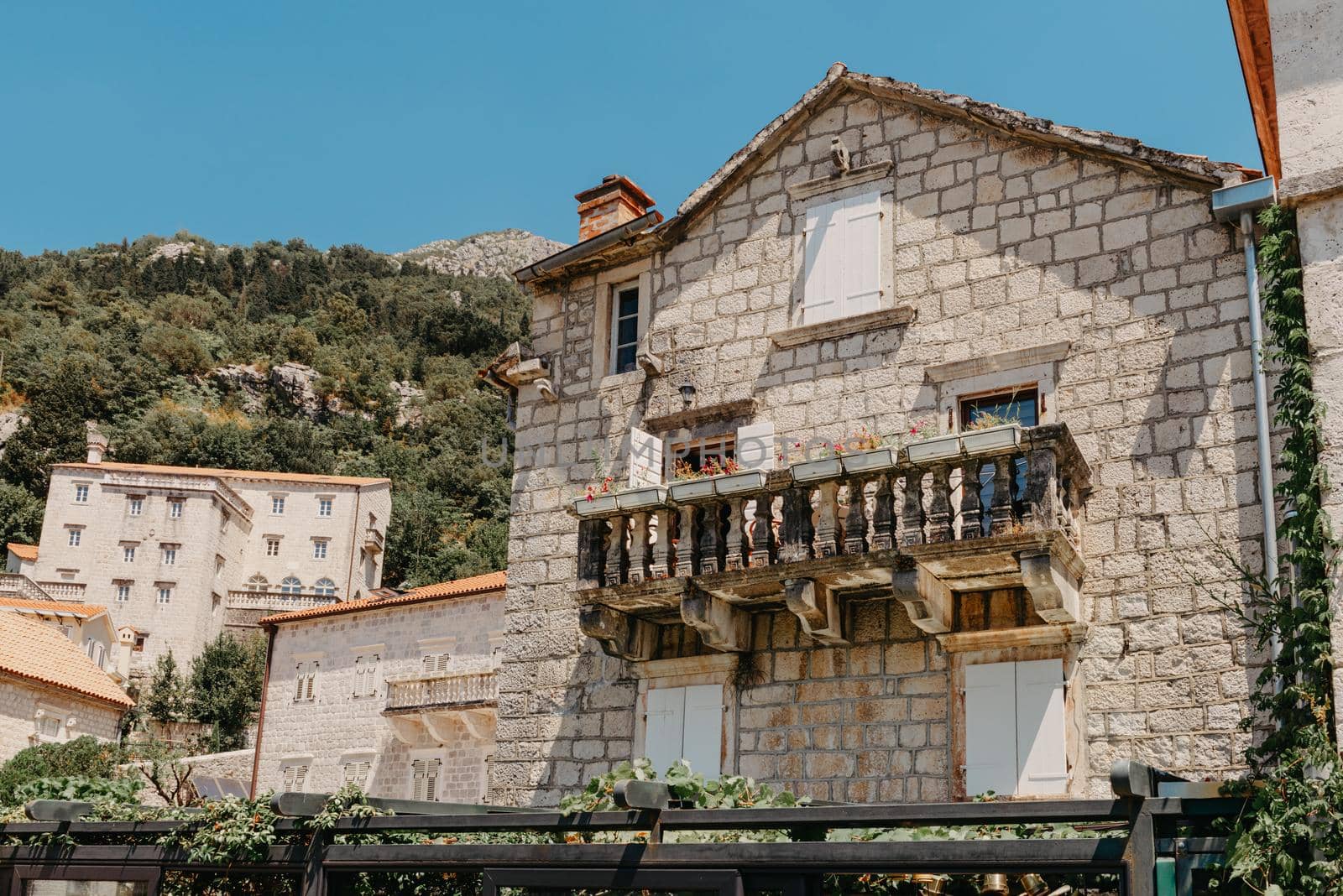 Historic city of Perast at Bay of Kotor in summer, Montenegro. Scenic panorama view of the historic town of Perast at famous Bay of Kotor with blooming flowers on a beautiful sunny day with blue sky and clouds in summer, Montenegro, southern Europe