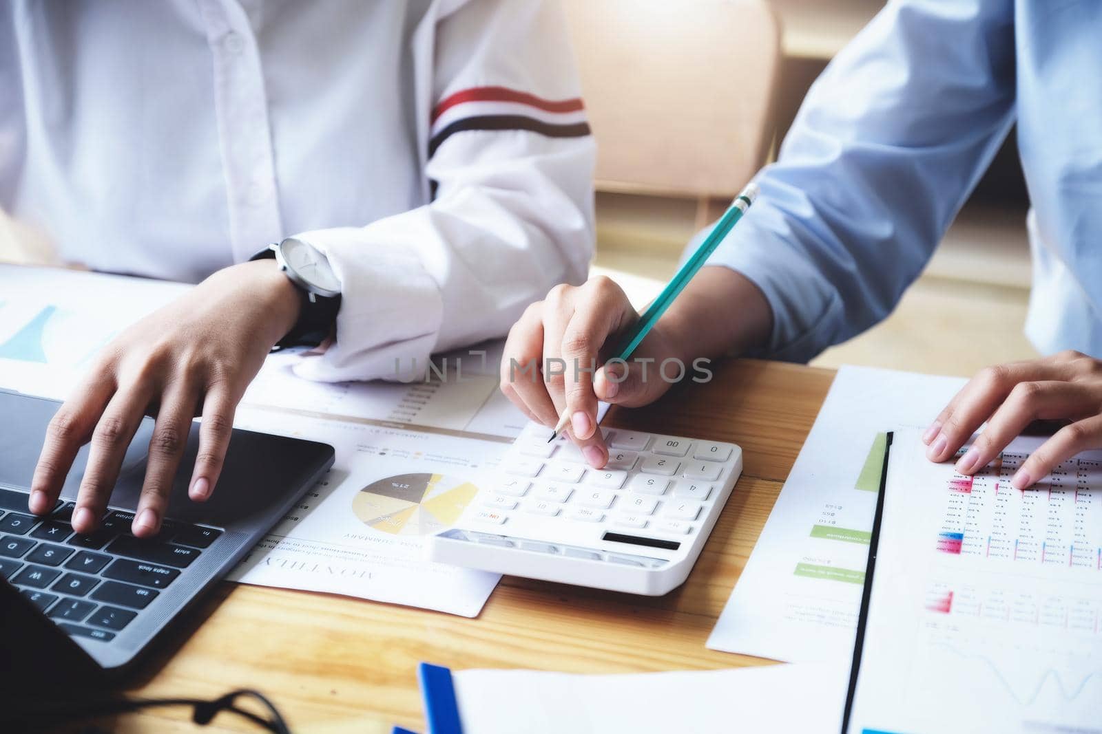 focus hand using calculator, Two young business executives are discussing to change their business concept to increase profits and the strength of their business with using calculator for work