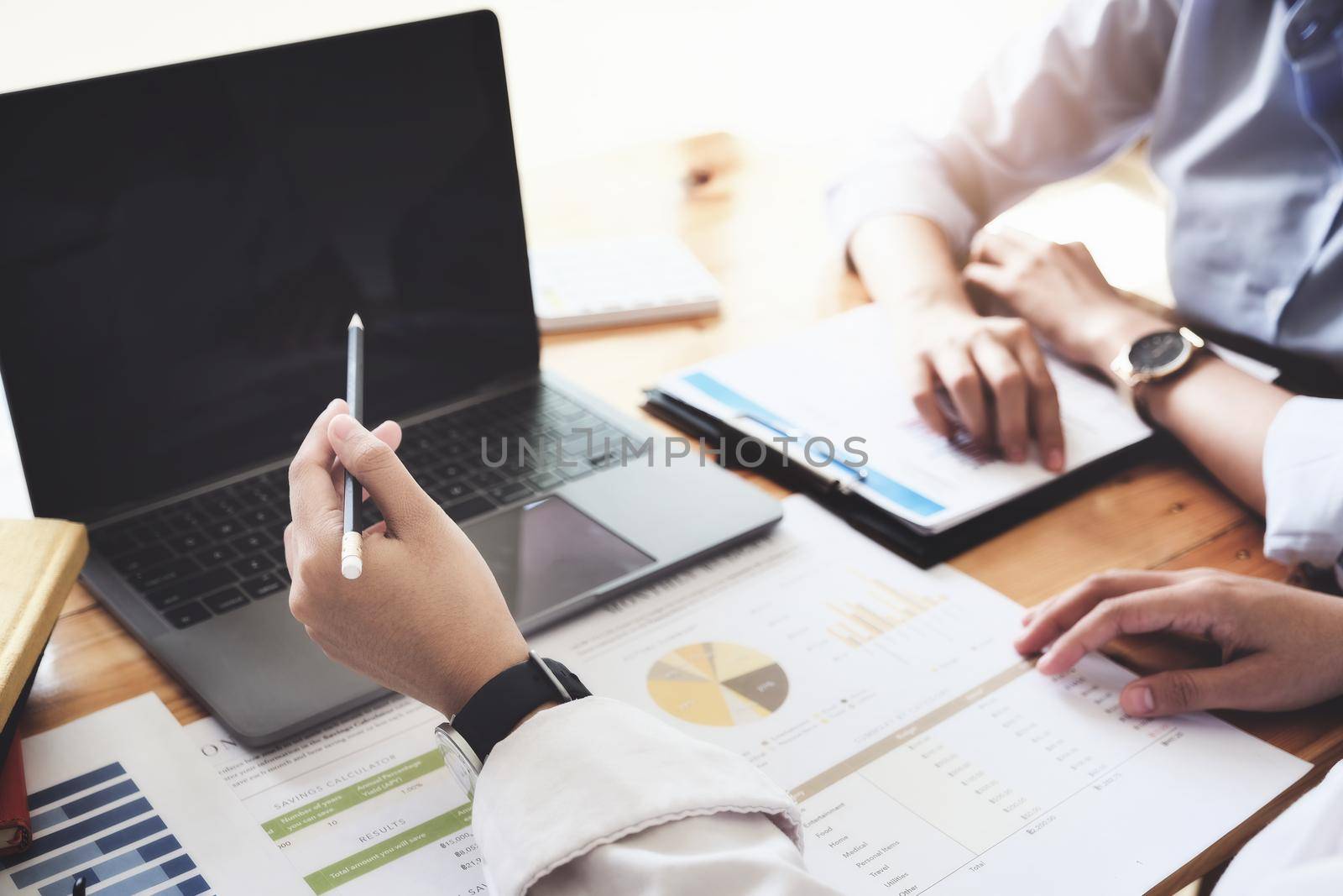 focus woman holding pen point laptop computer, A female business consultant describes a marketing plan to set business strategies for women business owners. by Manastrong