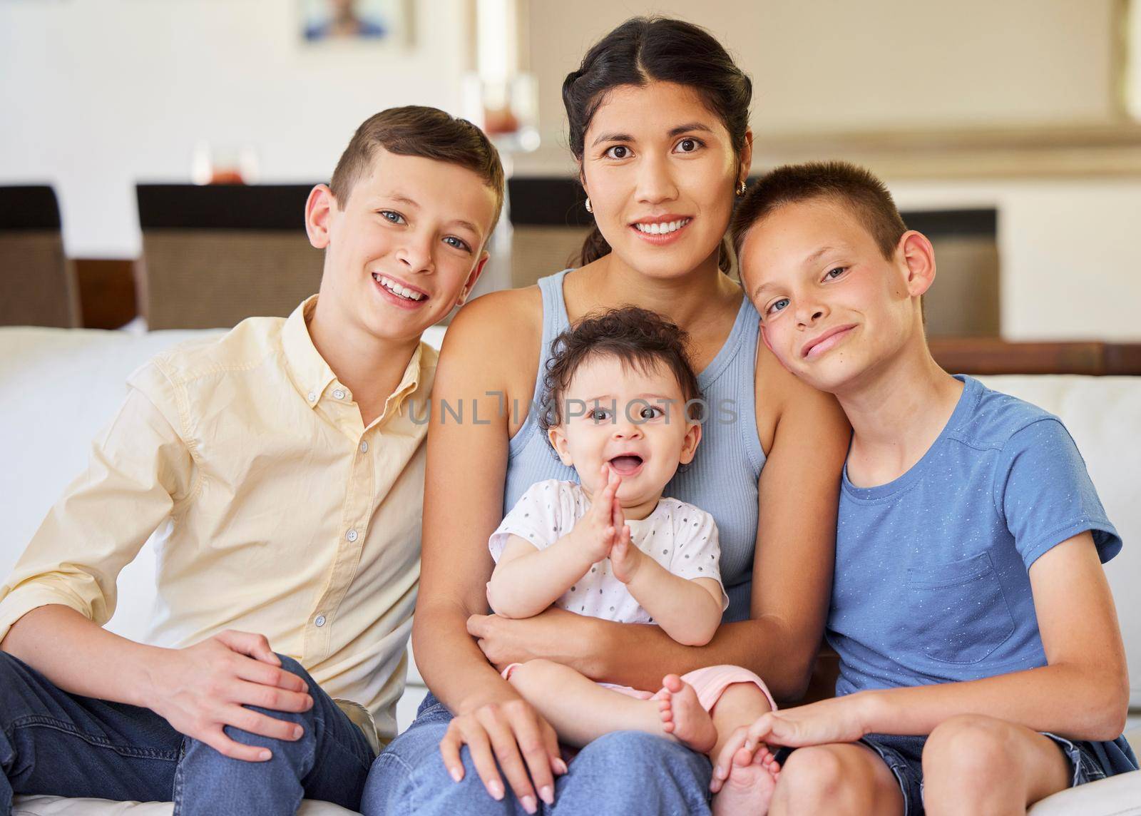 Portrait of a multiracial family at home.Mother with her adoptive sons. Young mother relaxing with her children. Mixed race family relaxing together at home. Boys spending time with their parent. by YuriArcurs