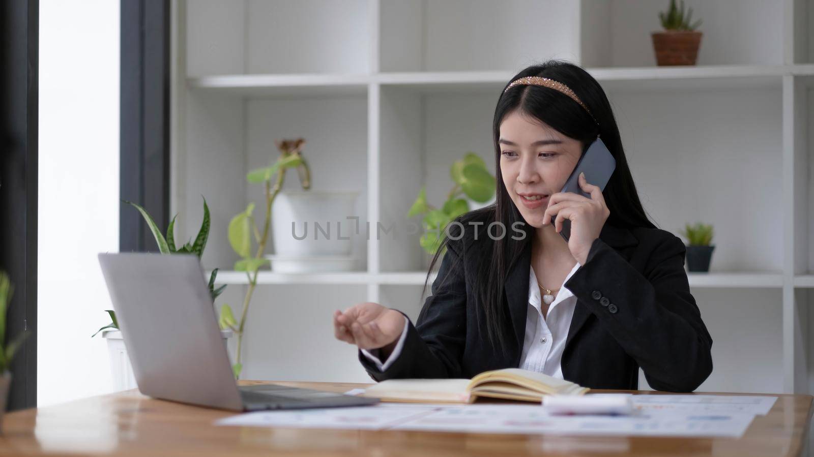 Asian businesswoman talking on the phone with customer in the office..