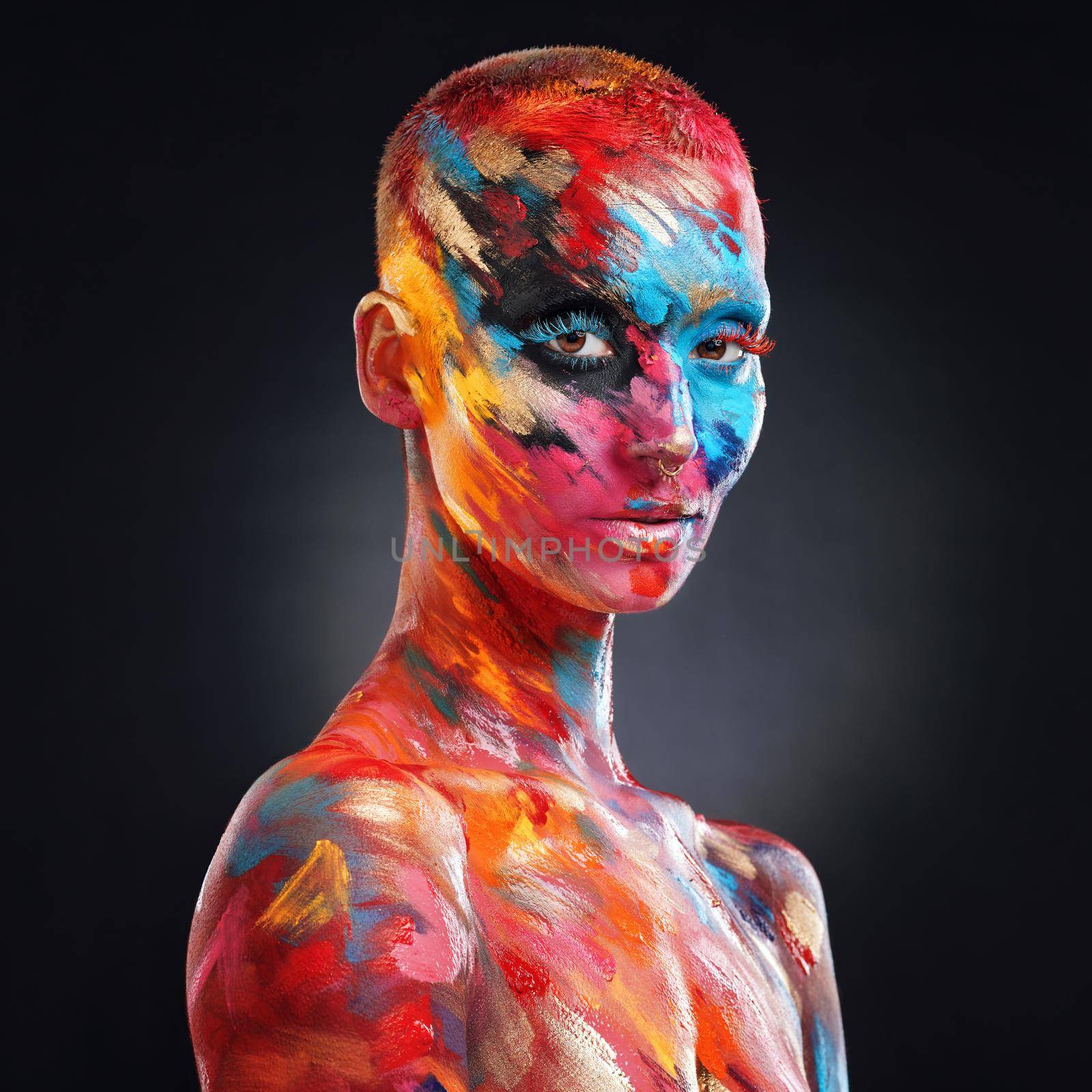 Even my flaws add to my masterpiece. an attractive young woman posing alone in the studio with paint on her face and body. by YuriArcurs