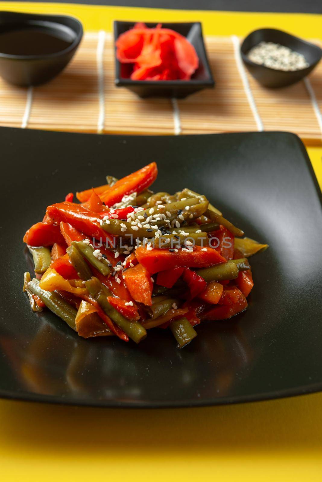 roasted vegetables in teriyaki sauce. Asian vegetables in sweet and sour sauce. Asian street food. Traditional Japanese and Chinese cuisine. Thai vegetables fried in sauce on a bright yellow background.