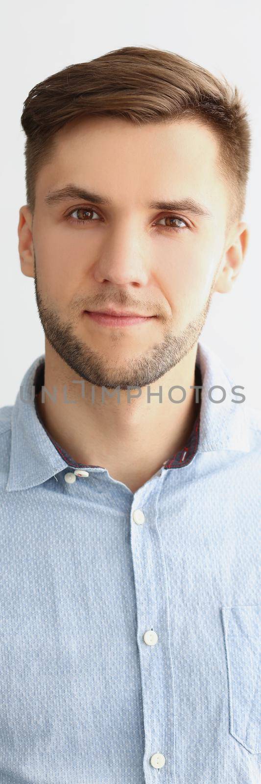 Portrait of successful young man in stylish grey shirt, presentable guy posing on white background. Confident man pose for picture. Success, status concept