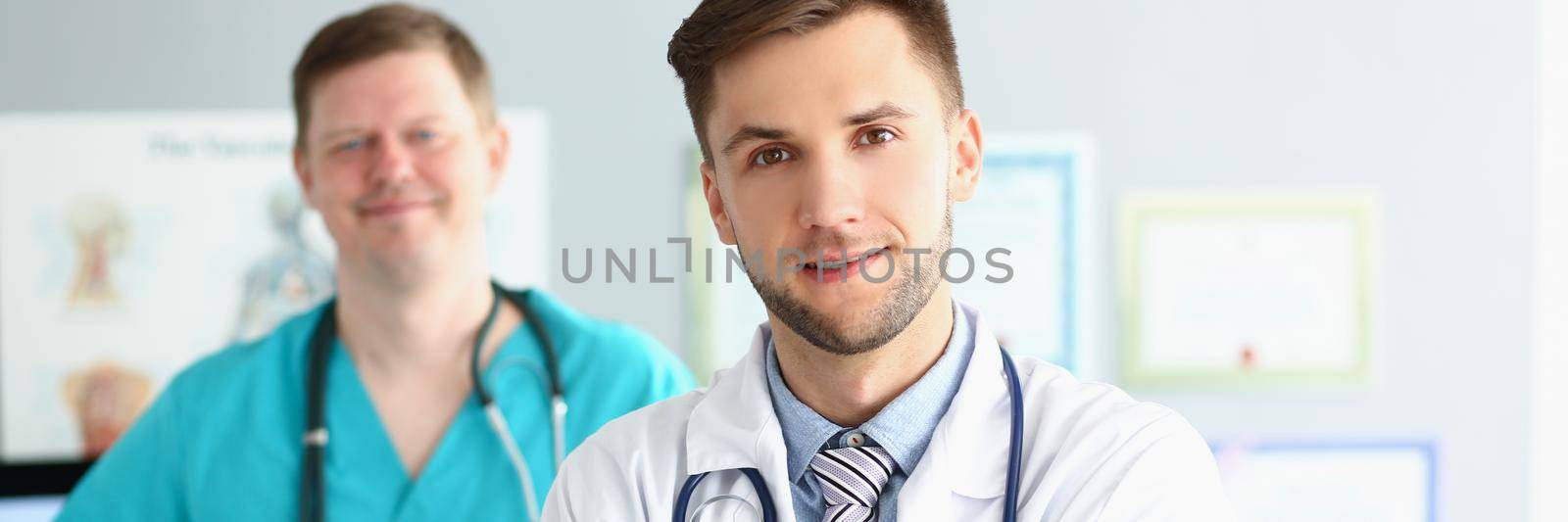 Medical male workers in uniform with stethoscopes, medical help, emergency team by kuprevich