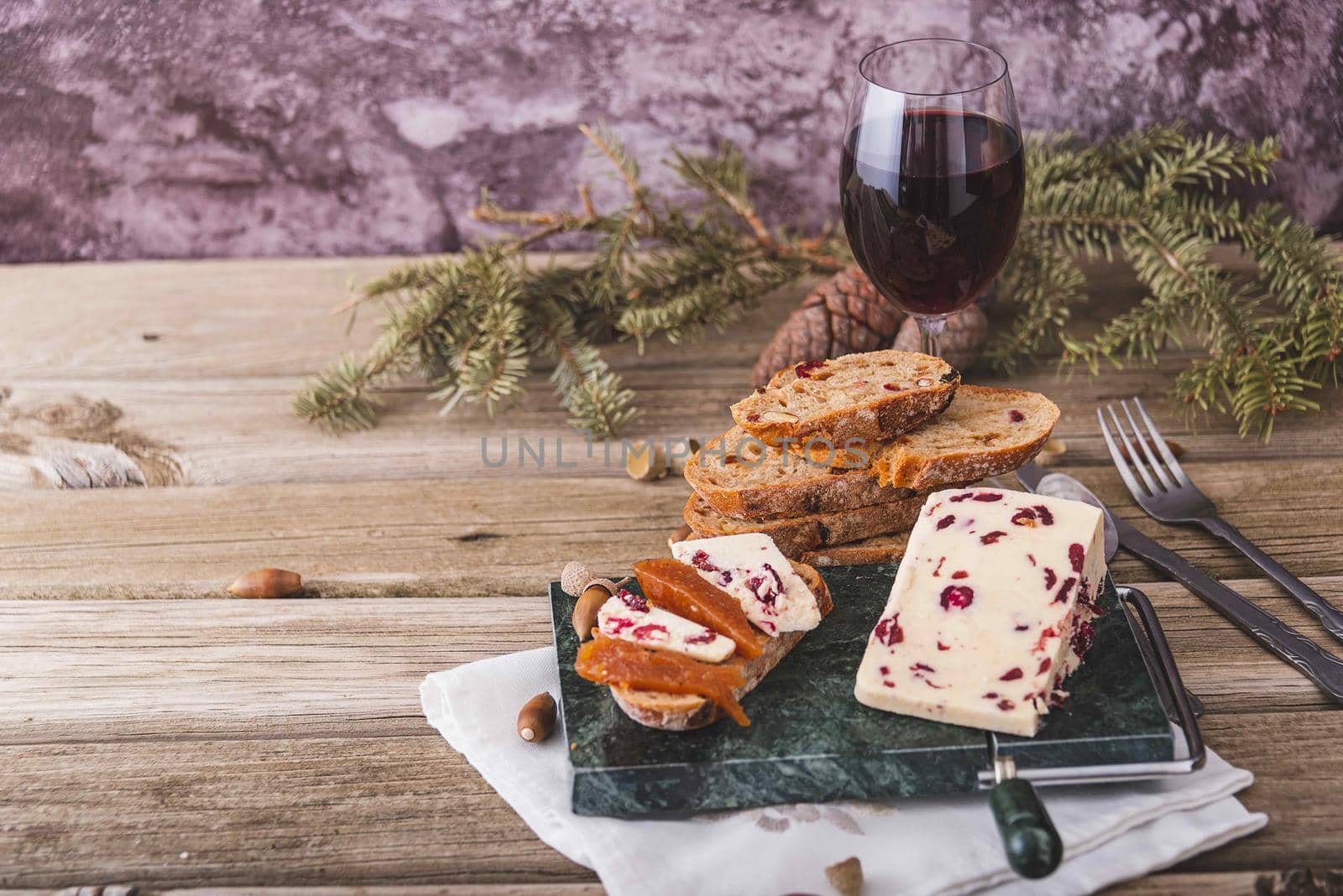 A closeup shot of Wensleydale cheese with cranberries and wine