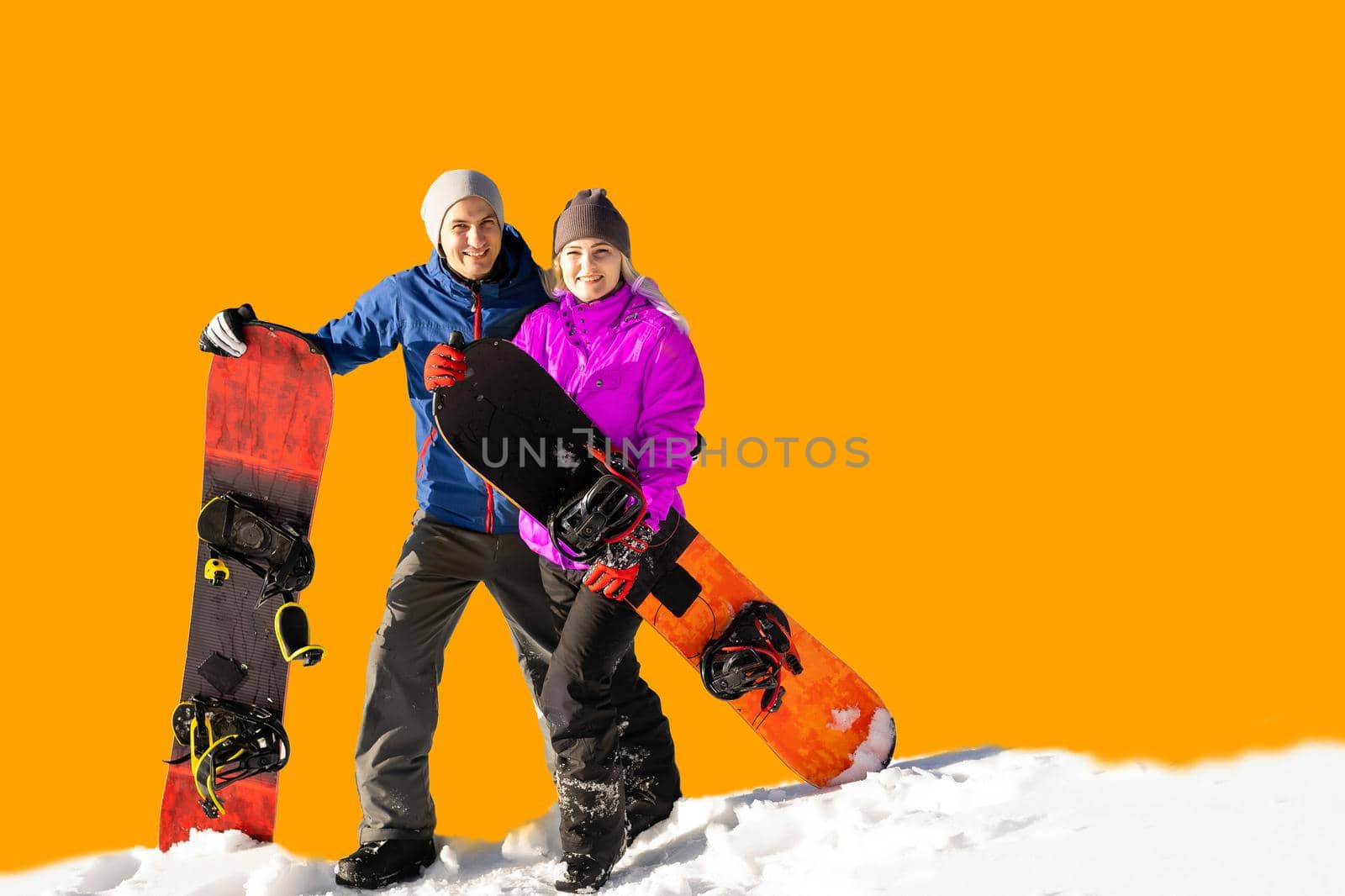 Happy couple of snowboarders having fun with snowboards.