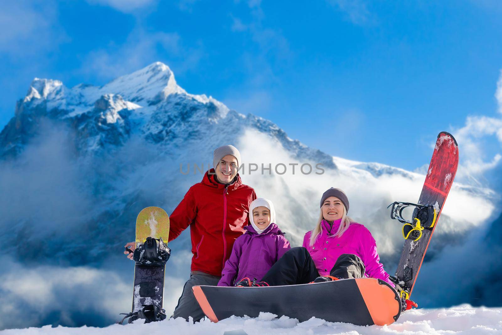 family and snowboard on snowy mountain.