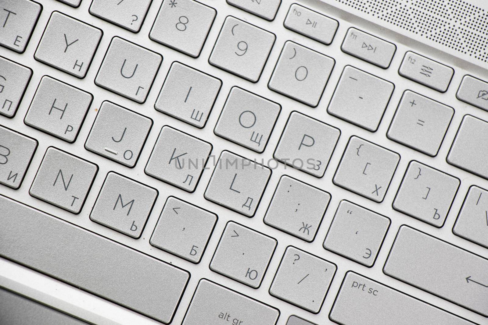 Laptop and notebook computer keyboard close-up, texts, keys and gray board.