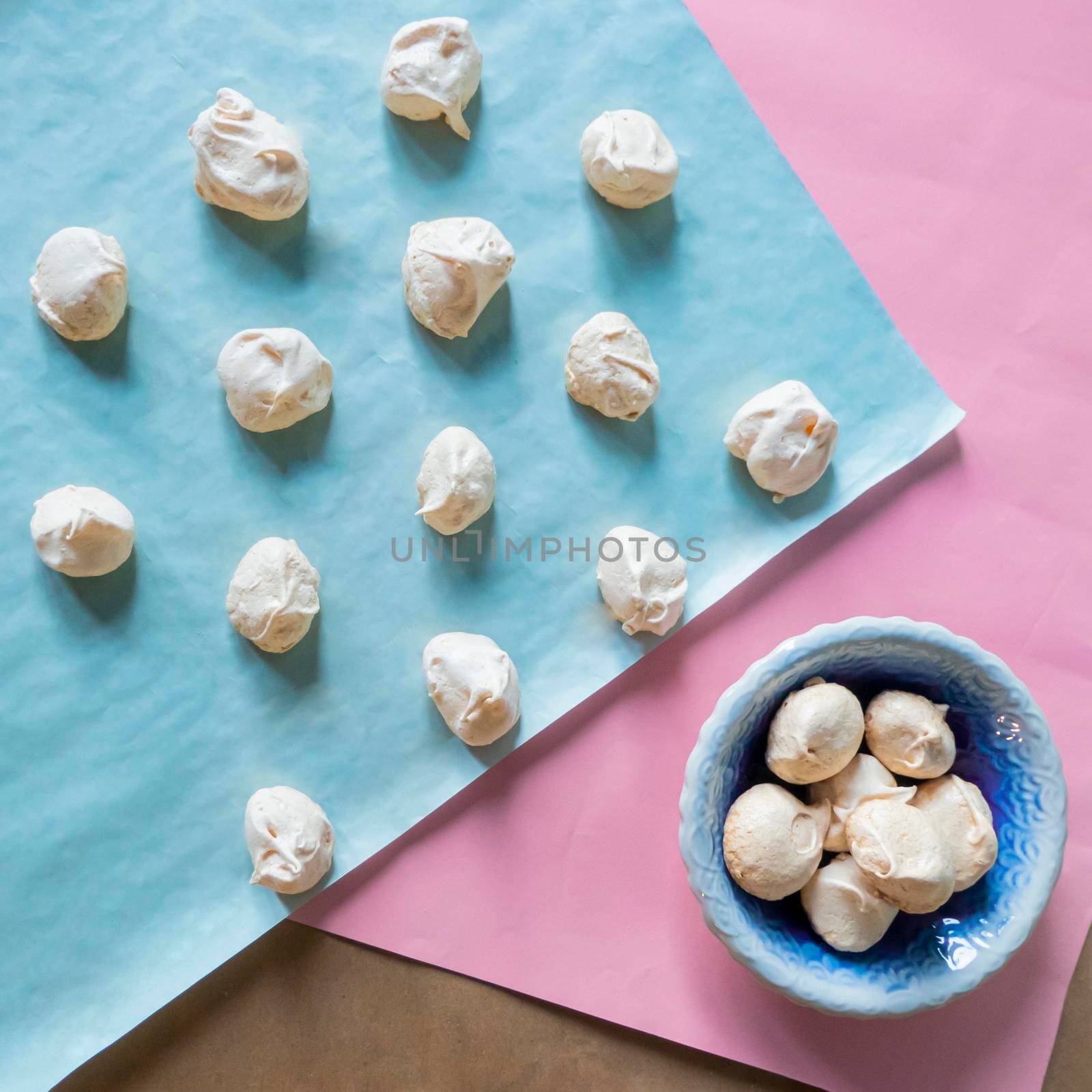 Homemade french milk-colored meringues on bluet paper. flatley composition: delicious homemade meringues on craft paper