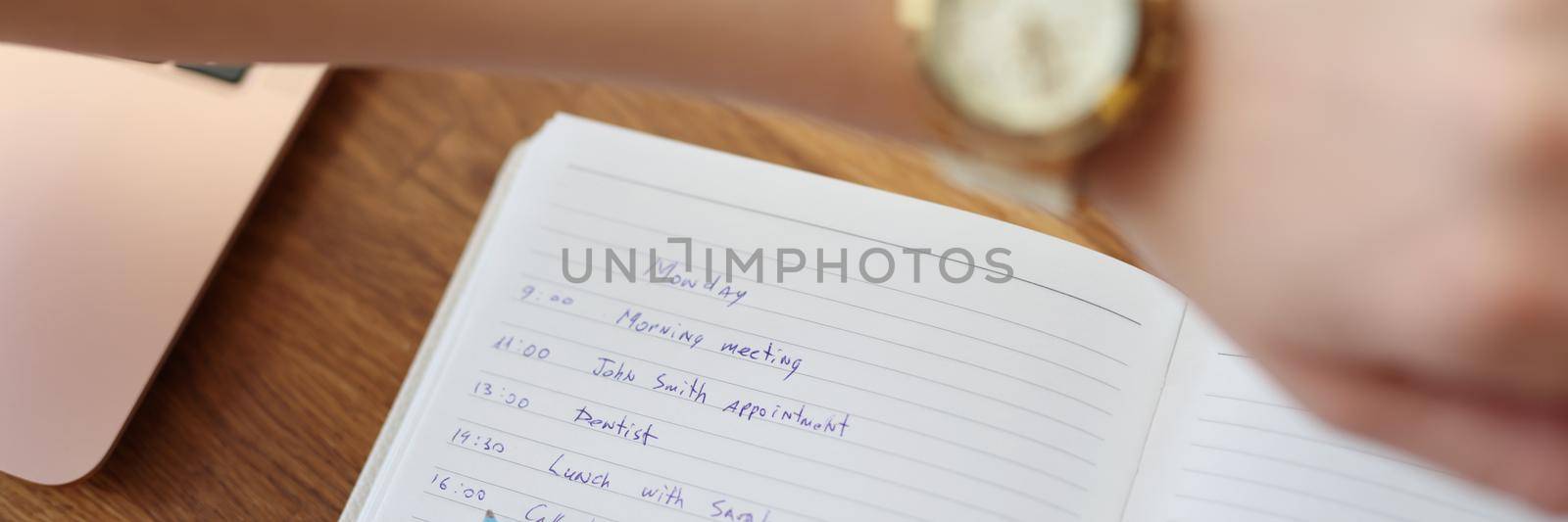 Woman write down plan for day, look at wristwatch to check time by kuprevich
