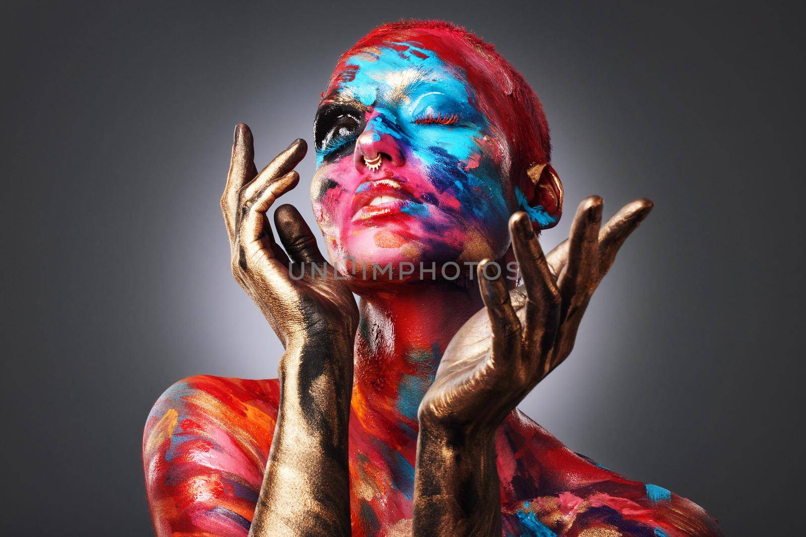 I dont want to be average. an attractive young woman posing alone in the studio with paint on her face and body. by YuriArcurs