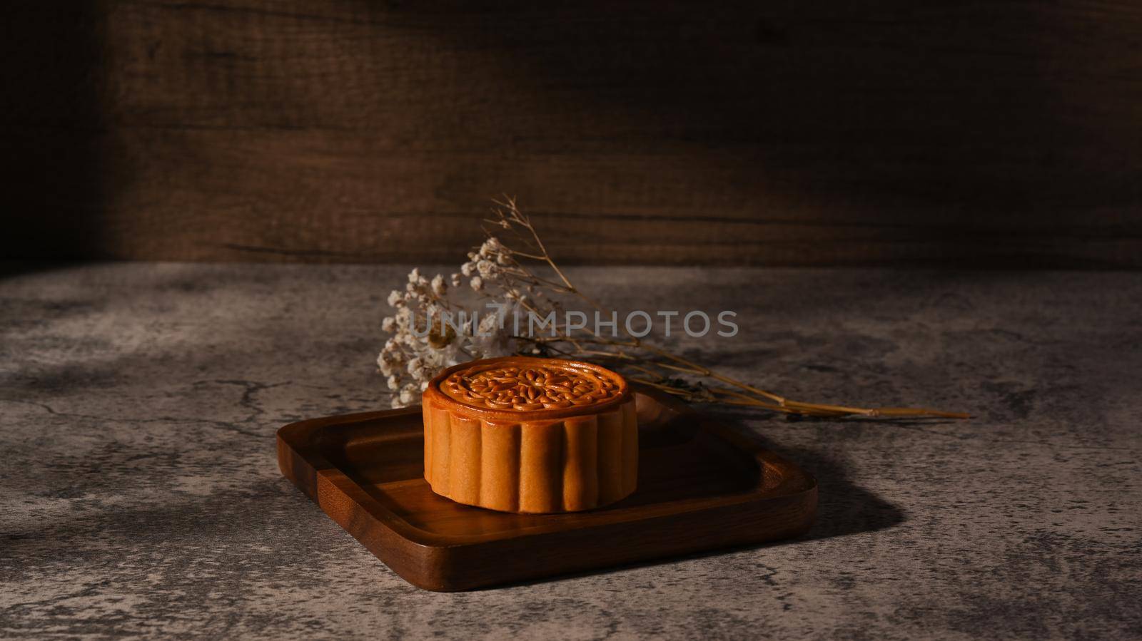 Delicious traditional mooncake on wooden tray. Mid Autumn festival and Chinese traditional dessert.