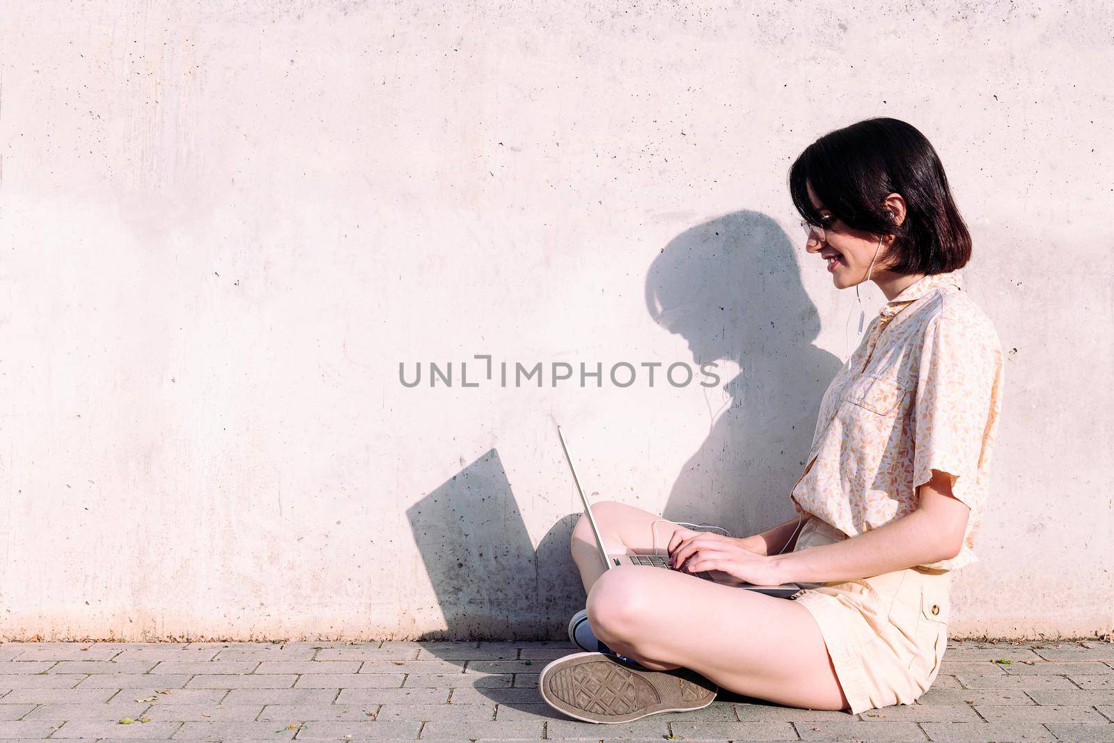 young woman with earphones working with a computer by raulmelldo