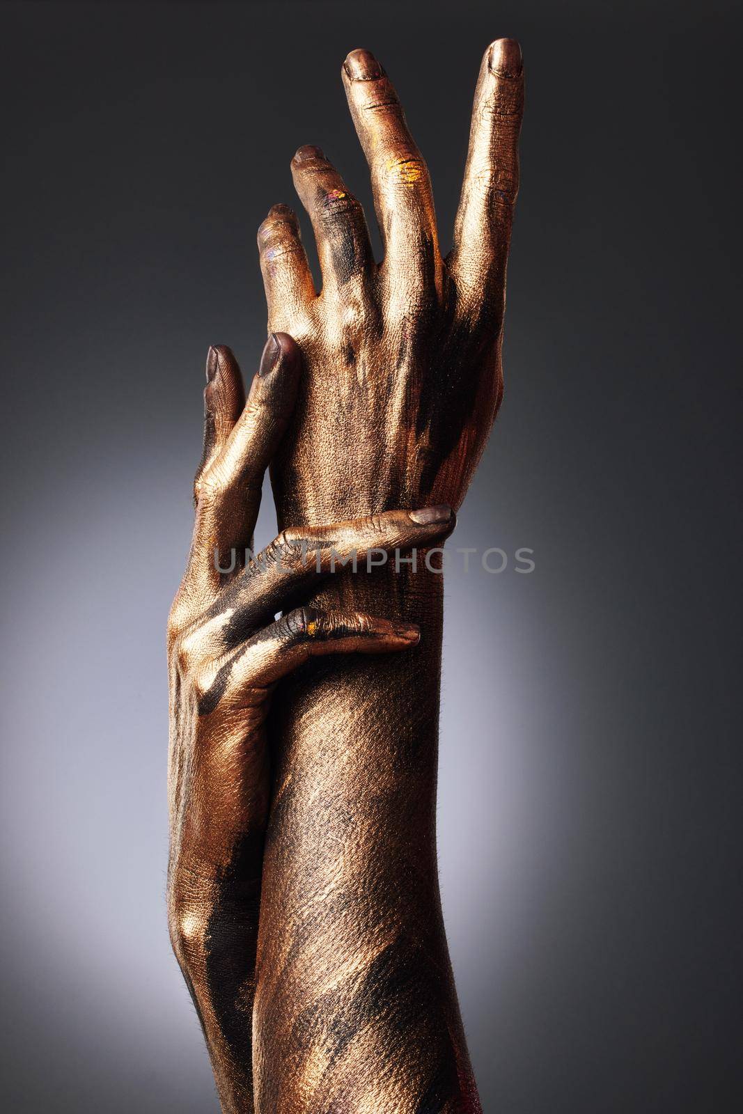 There is something godly about her. an unrecognisable woman posing alone in the studio with paint on her hands