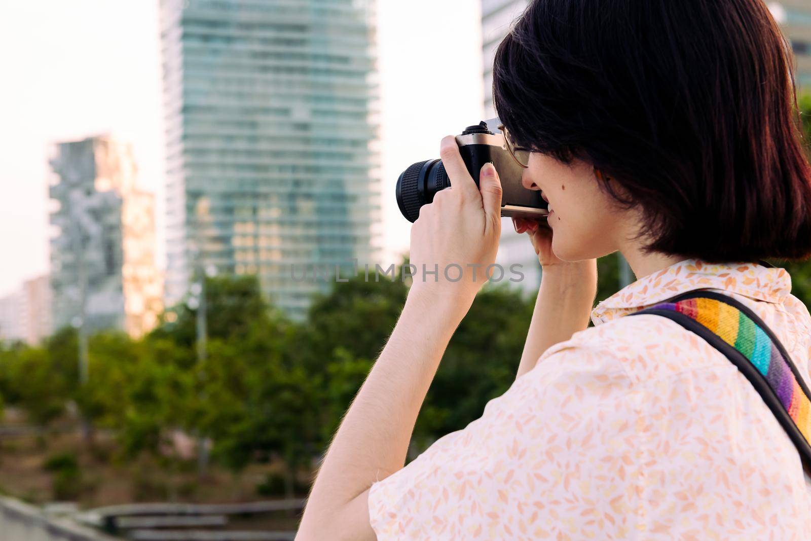 young tourist woman taking a photo with an old camera, concept of youth and creative lifestyle, copy space for text