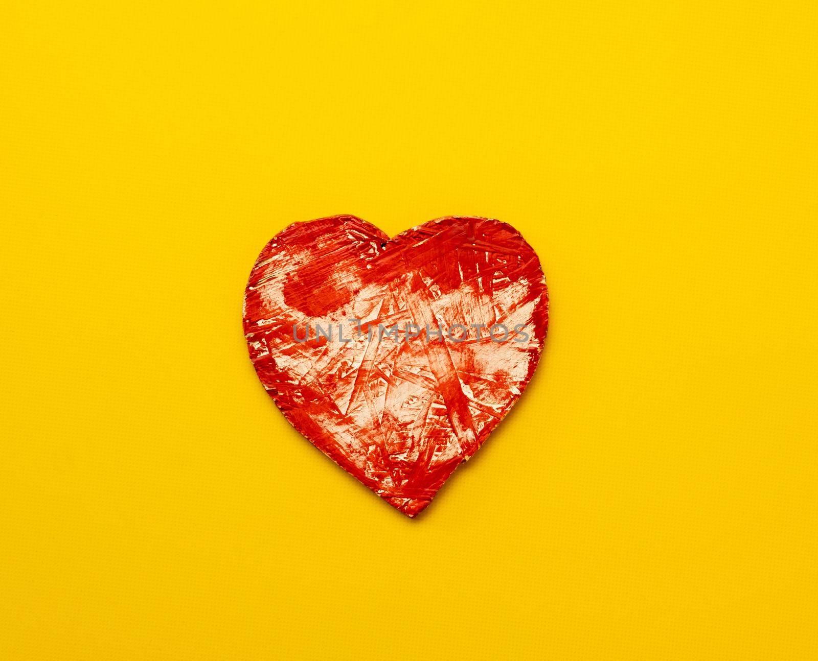 Red heart isolated on yellow background with copy space. Concept of love and feelings. Abstract symbol of passion and affection