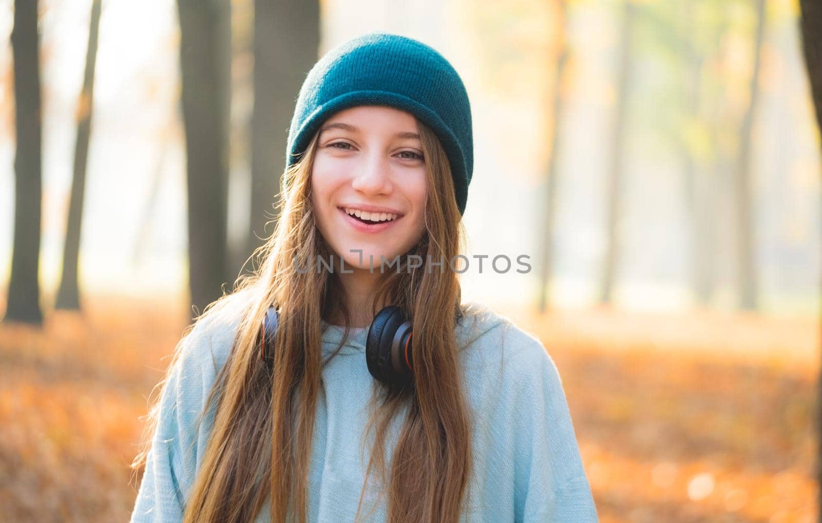 Nice girl with headphones in autumnal nature