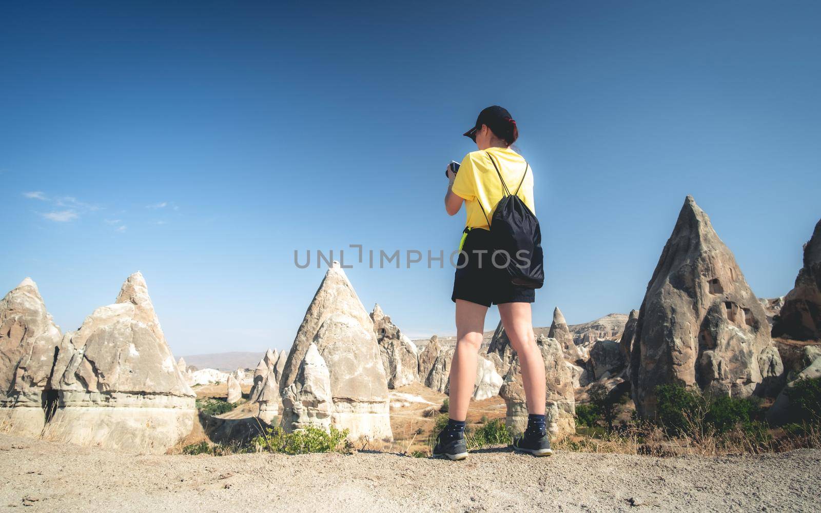 Woman tourist taking pictures of mountains in Cappadocia, Turkey
