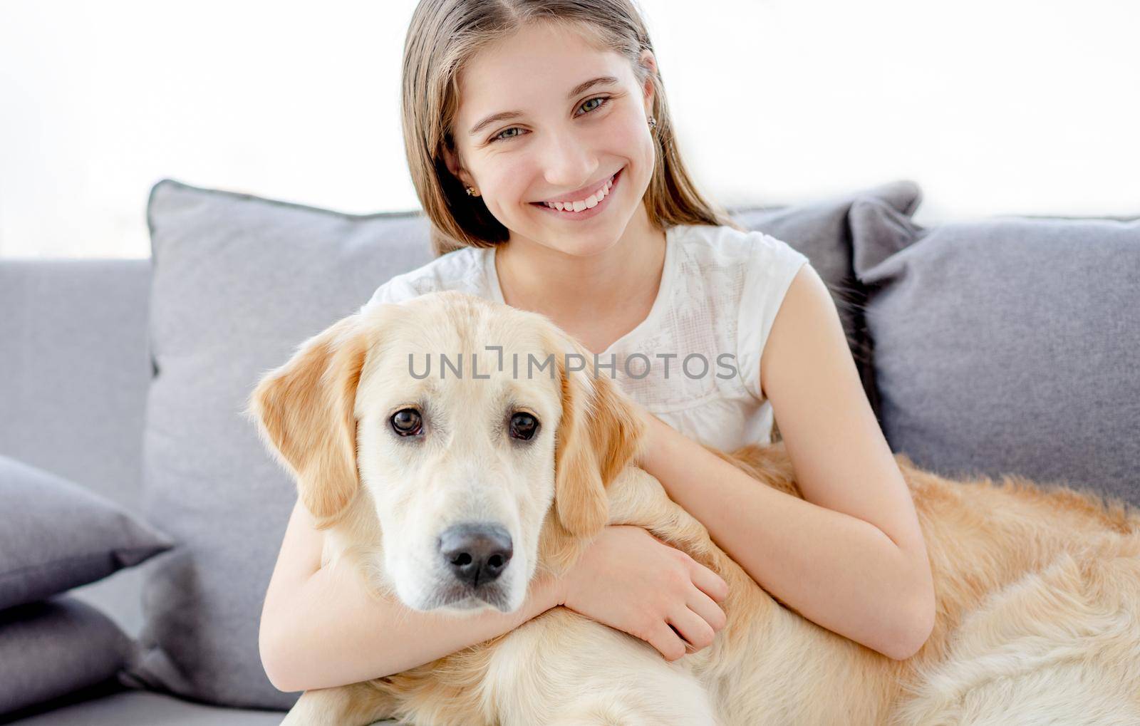 Smiling teenage girl with adorable dog in light room