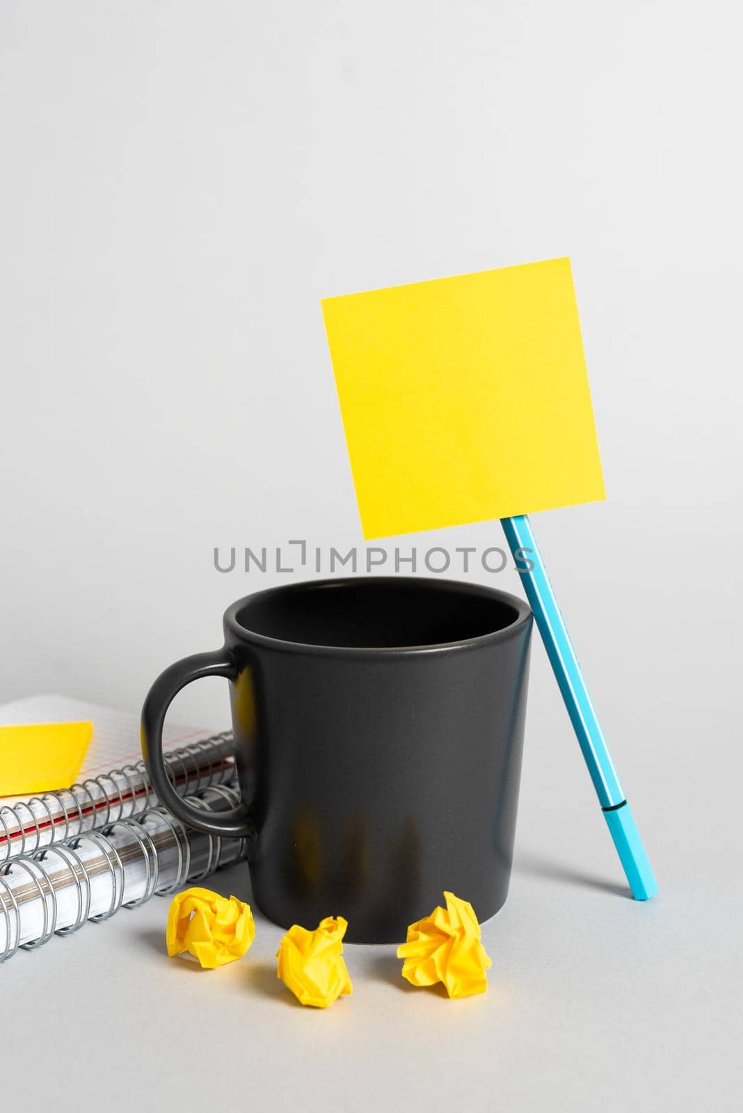 Cup, Pen, Notebooks, Paper Wraps And Sticky Note With Important Message On Desk. Mug, Pencil, Books And Crutial Announcement On Table. Coffee, Ball Point And Critical Data. by nialowwa