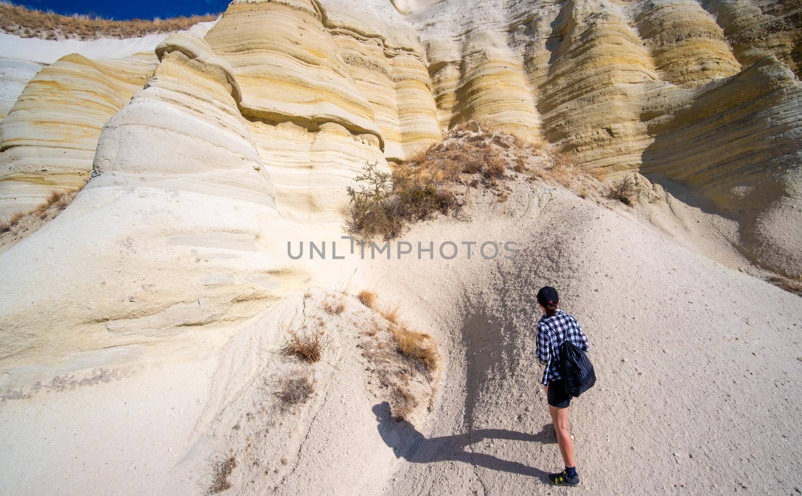 Tourist trekking on feet of sandy mountain in Cappadocia, Turkey